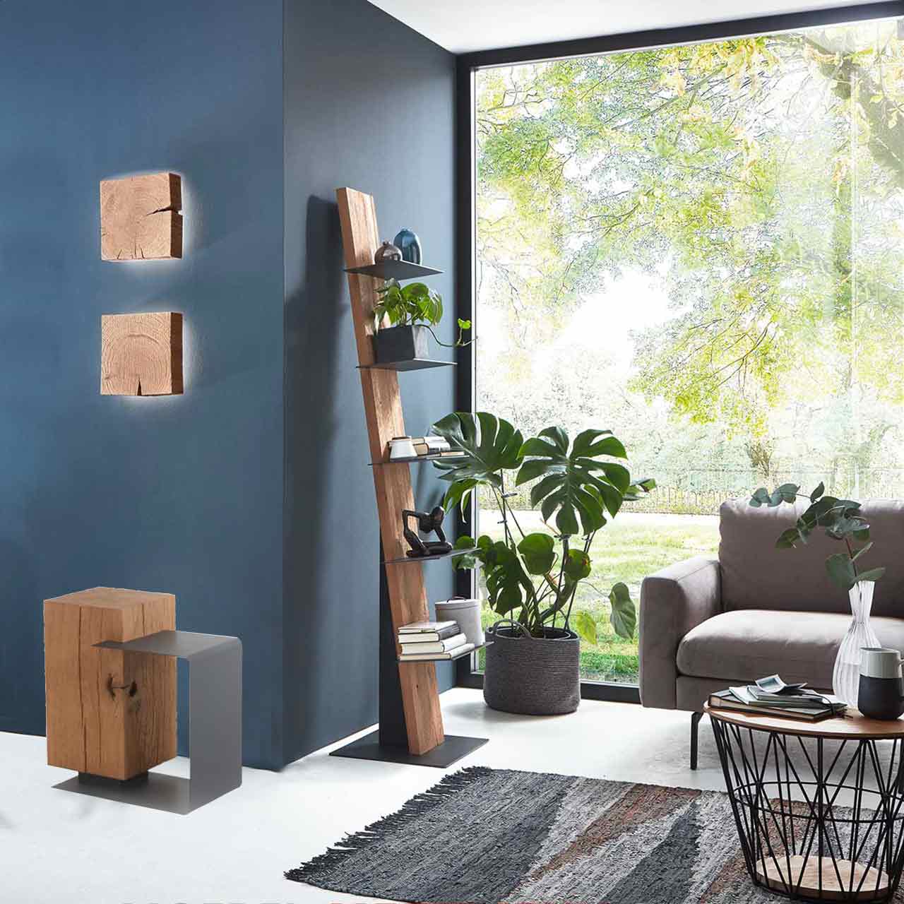 Milieubild Wohnzimmer - Hartmann NATURSTÜCKE 7160-1005 Modernes Wohnzimmer mit rechteckigem Beistelltisch aus Kerneiche und Metall, zwei Wandlampen aus Massivholzblock, rechts ein passendes Stehregal mit Ablagen. Davor ein runder Beistelltisch mit Metallkorb.