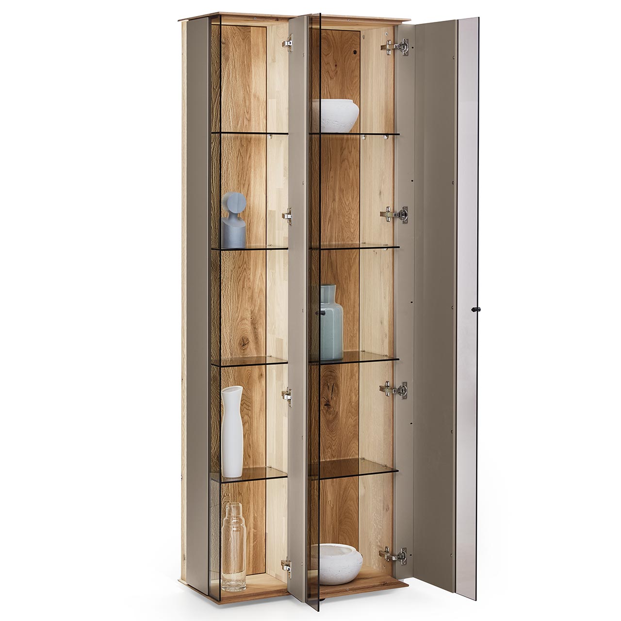 Hartmann Möbel SVEA - Standvitrine 8660-0062 offen - Kerneiche Natur, Lack Sand Moderne Standvitrine aus massiver Kerneiche Natur mit Lackfronten in Sand. Mit zwei geöffneten Glastüren in asymmetrischem Design. Dahinter sichtbar Glaseinlegeböden und die beleuchtete Riffholzrückwand.