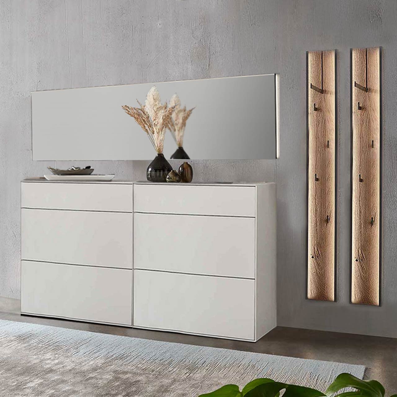 Moderne fünfteilige Garderobe aus massiver Kernbirke weiß lackiert: Zwei Stauraumschränke mit Schubkästen, zwei Garderobenpaneele mit je einer Kleiderstange, vier Mantelhaken und Spaltholz-Akzent und ein langer Wandspiegel. 