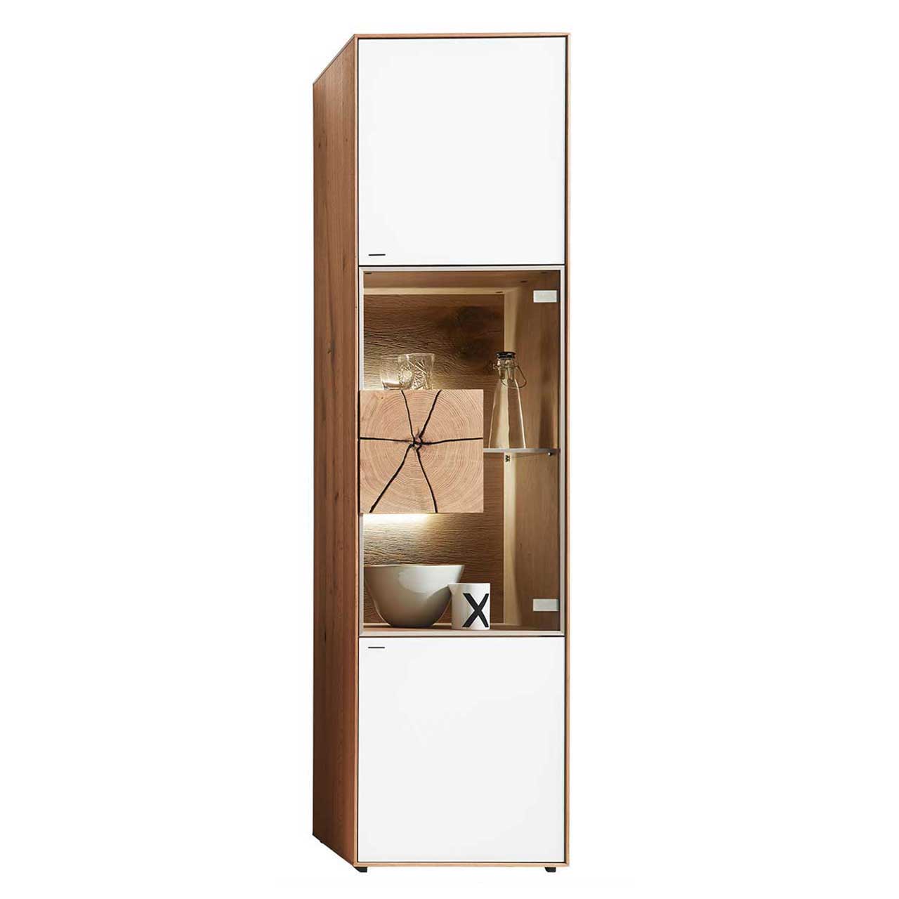 Moderne Standvitrine aus massiver Kerneiche Umato mit Mattglas weiß Front, mittig mit beleuchtetem Glasausschnitt, Glasboden und Hirnholzblock aus hellem Holz. 