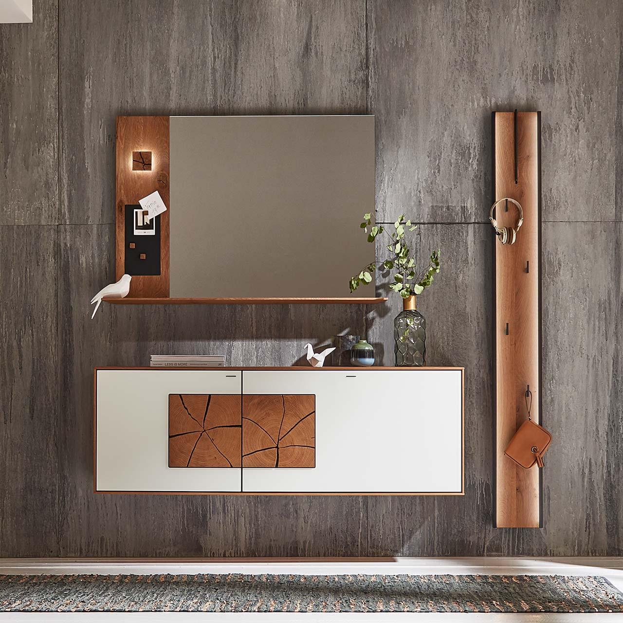Moderne Garderobenkombination aus massivem Holz mit beleuchtetem Spiegelpaneel, Hängeschrank mit Mattglas weiß Front und Hirnholzscheiben und einem Garderobenpaneel mit Ablage und Haken – vor grauer Wand.