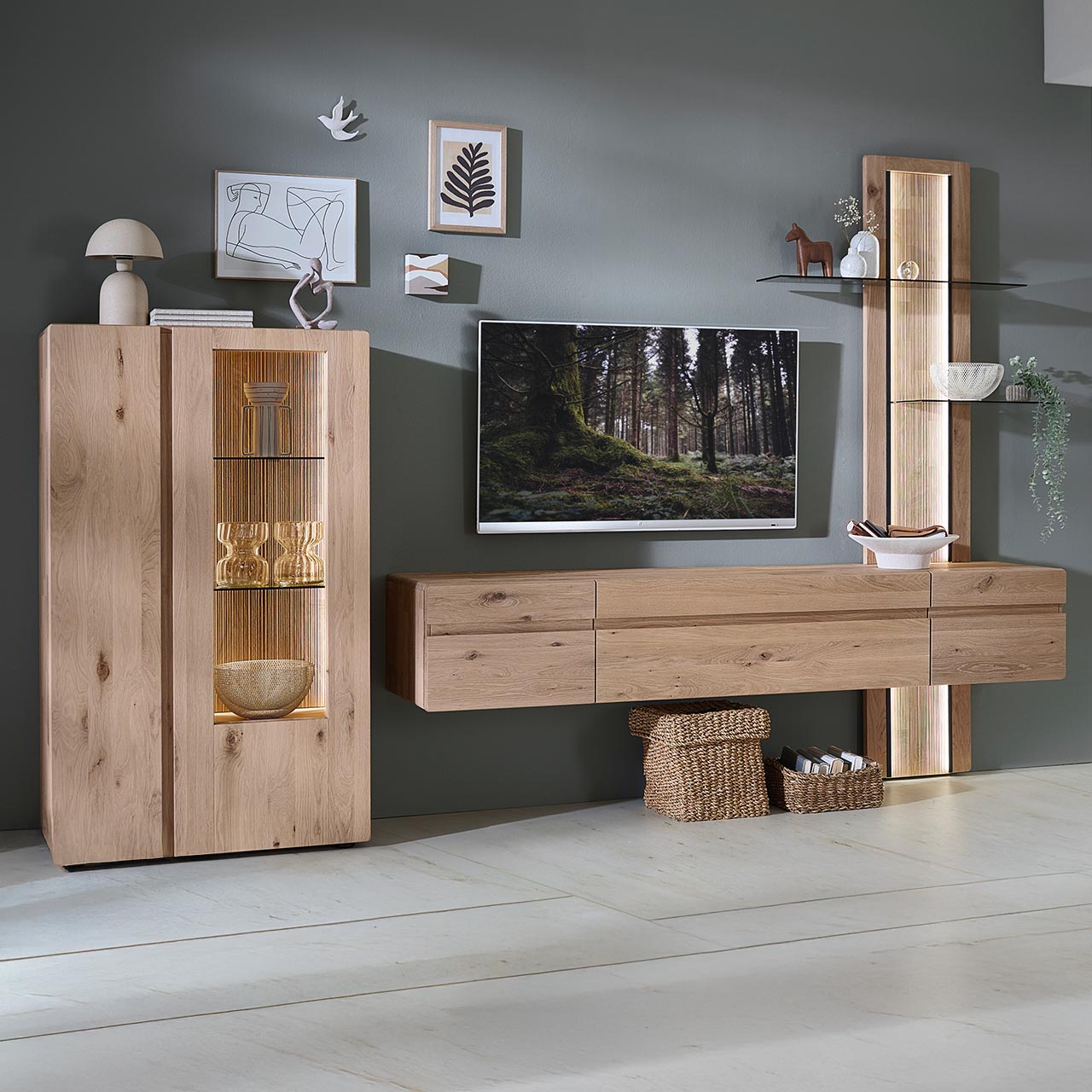 Moderne dreiteilige Wohnwand aus massiver Kerneiche Natur bestehend aus einem Highboard mit Holz-/Glastüren, einem langen Hängelowboard und einem integriertem Aufsatzpaneel mit Glasböden und beleuchteter, geschroppter Rückwand.