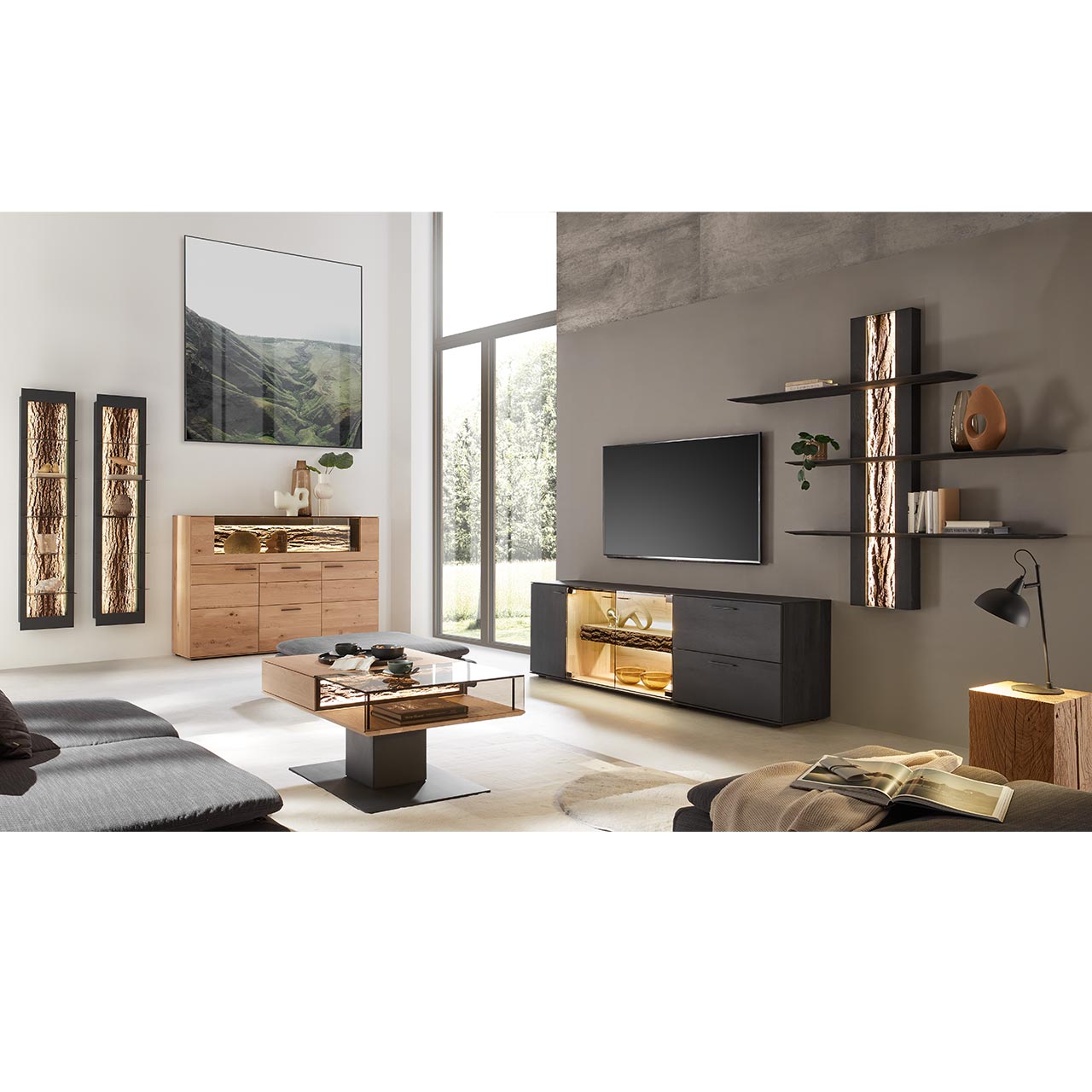 Modernes Wohnzimmer mit Wohnwand bestehend aus Lowboard aus massiver, anthrazit gebeizter Kerneiche mit beleuchtetem Glasausschnitt und einem Wandpaneel mit drei langen Ablageböden. Links das passende Highboard und zwei Hängeregale. 