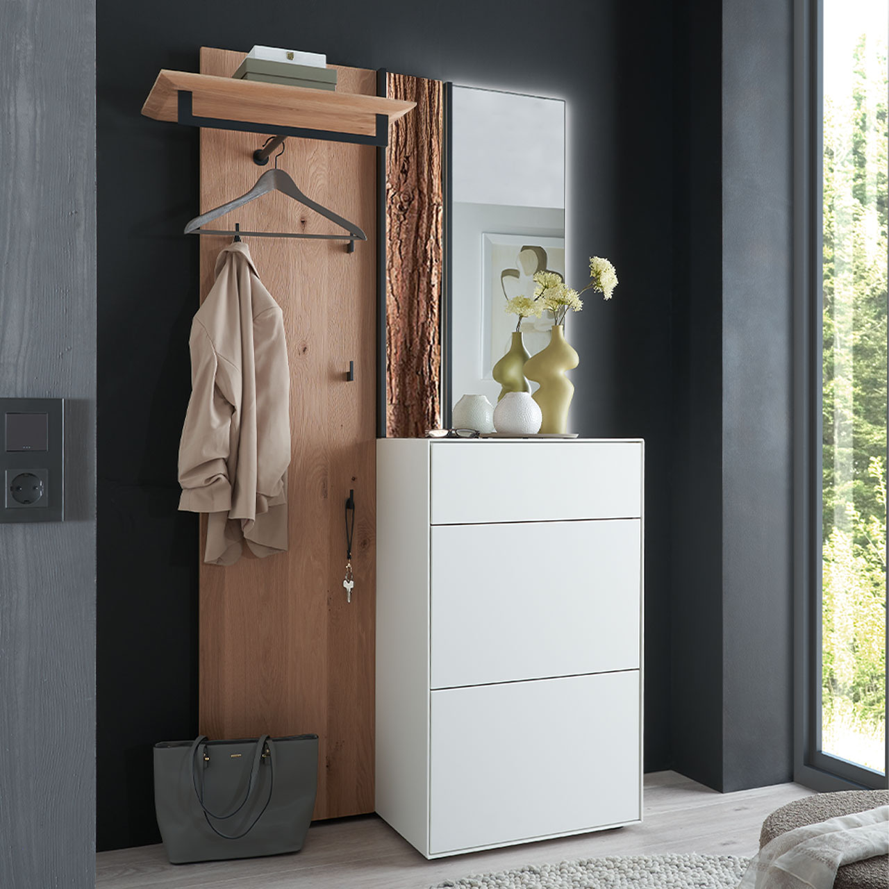 Hartmann SALVO 8550G - Garderobe Nr. V110R - Kernbirke weiß Lack, Kerneiche Natur, Baumrinde Moderne dreiteilige Garderobe aus Kernbirke und Kerneiche Natur: Wandpaneel aus Holz mit Kleiderstange, Haken und Rinden-Akzent, ein Stauraumschrank mit Schubkasten und Klappen in Lack weiß und ein rechteckiger Spiegel.