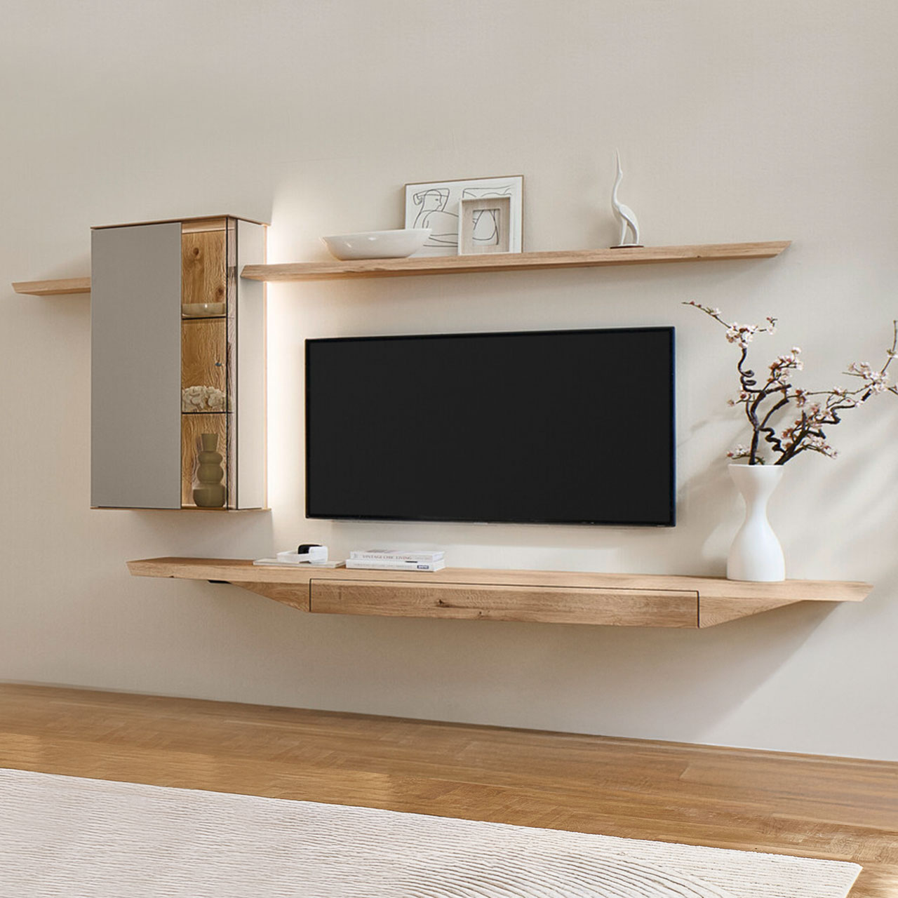 Moderne vierteilige Wohnwand aus massiver Kerneiche Natur mit Lack Sand und Riffholz, bestehend aus einem Hängelowboard mit Schubkasten aus massivem Riffholz einer Hängevitrine in Holz/Lack sowie zwei Wandboarden mit Holzboden - im asymmetrischen Design.