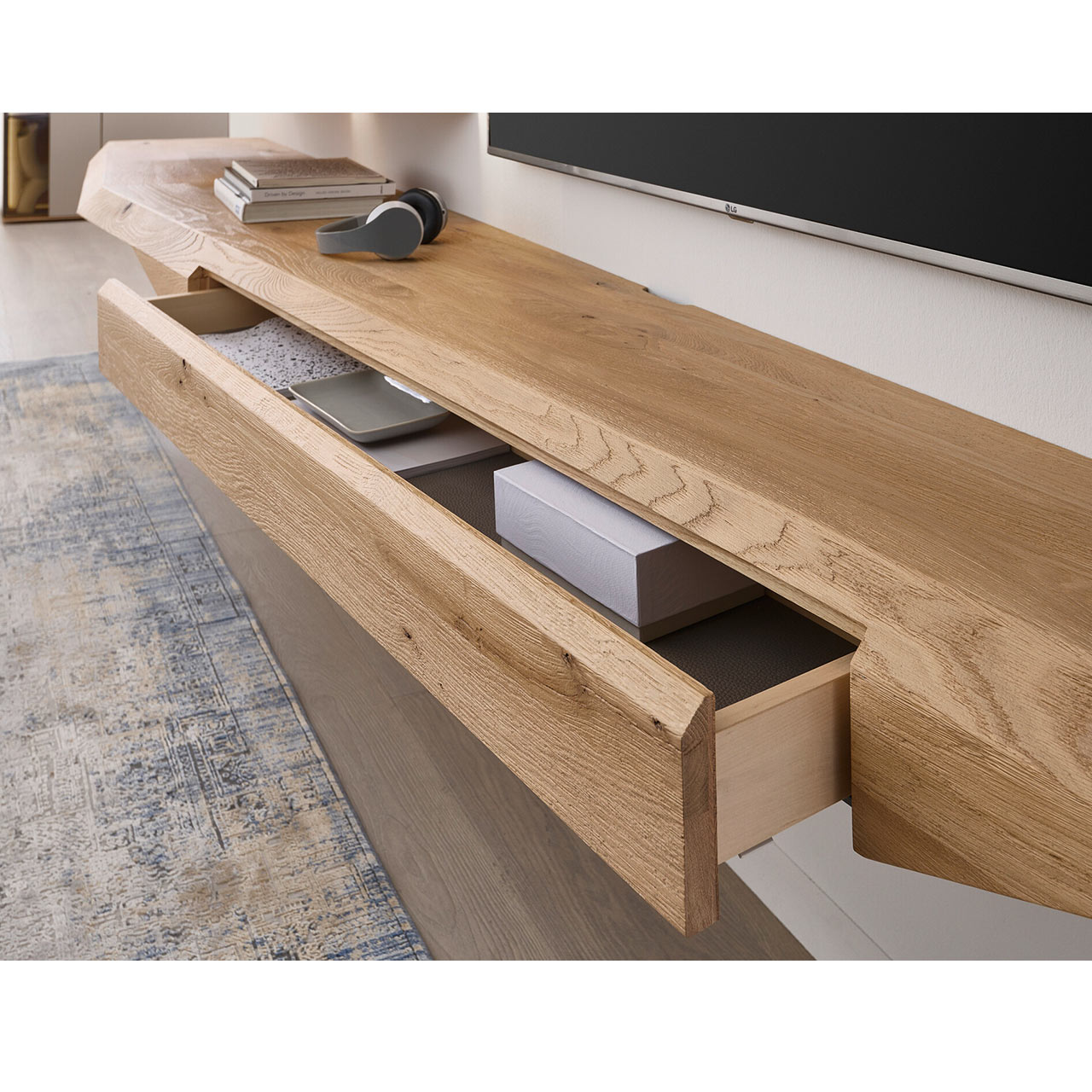 Modernes, langes Hängelowboard aus massivem Riffholz im asymmetrischem Design mit geöffnetem Schubkasten.