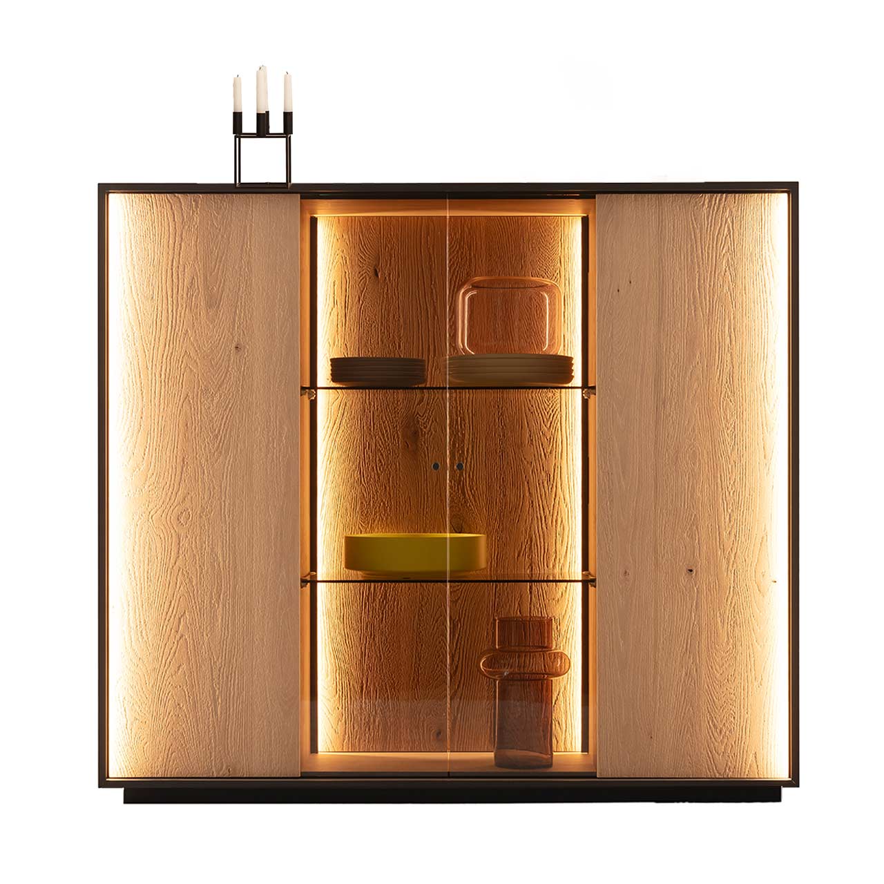 Hartmann YOLA Schöner Wohnen - Highboard mit Sockel 8590-6132 Modernes Highboard auf Sockel aus massiver, sandgestrahlter Kerneiche Natur mit beleuchtetem, rundum Metallrahmen. Mit zwei Holztüren links und rechts, mittig verglaster Vitrinenbereich mit Glaseinlegeböden und integrierter Beleuchtung.