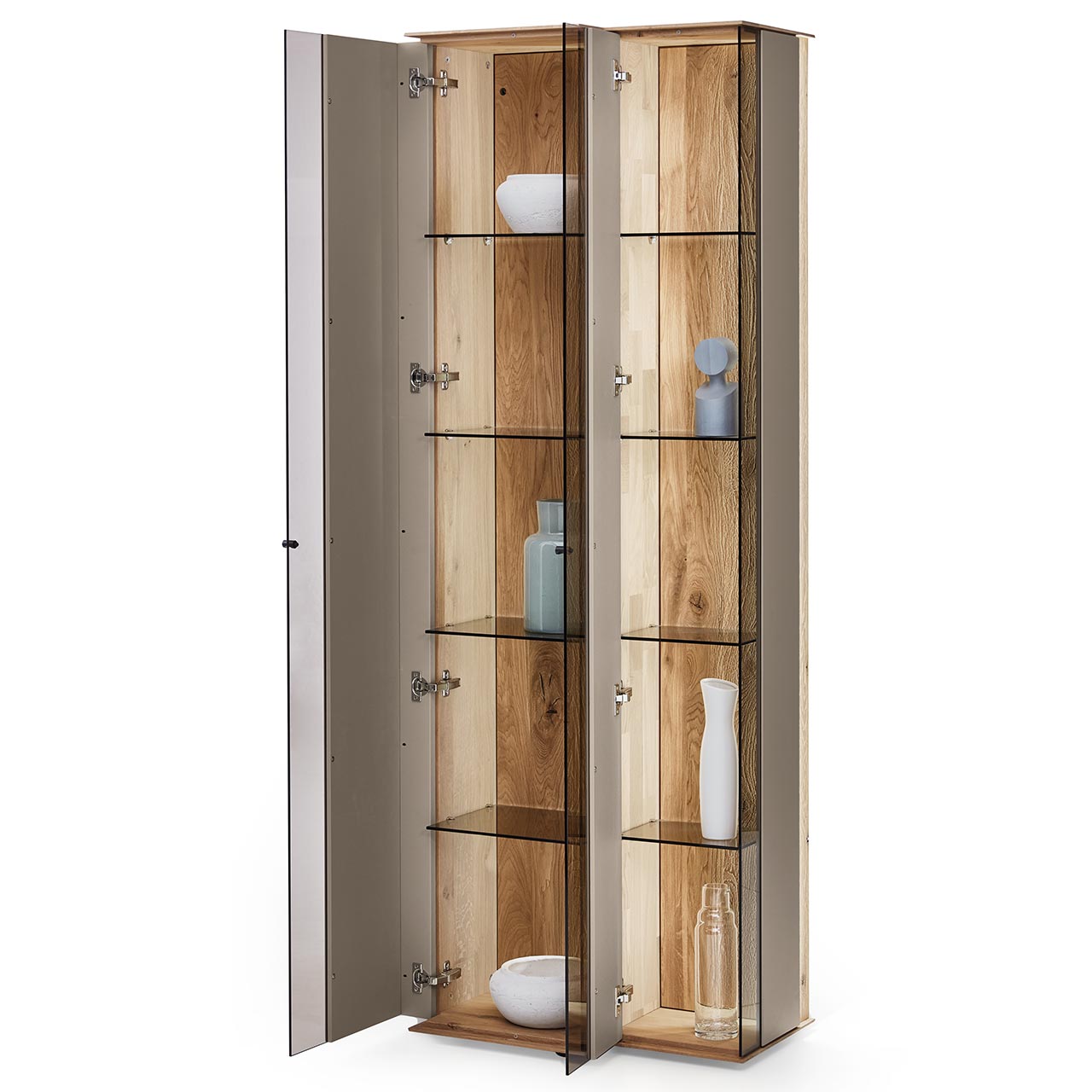 Hartmann Möbel SVEA - Standvitrine 8660-0061 offen - Kerneiche Natur, Lack Sand Moderne Standvitrine aus massiver Kerneiche Natur mit Lackfronten in Sand. Mit zwei geöffneten Glastüren in asymmetrischem Design. Dahinter sichtbar Glaseinlegeböden und die beleuchtete Riffholzrückwand.