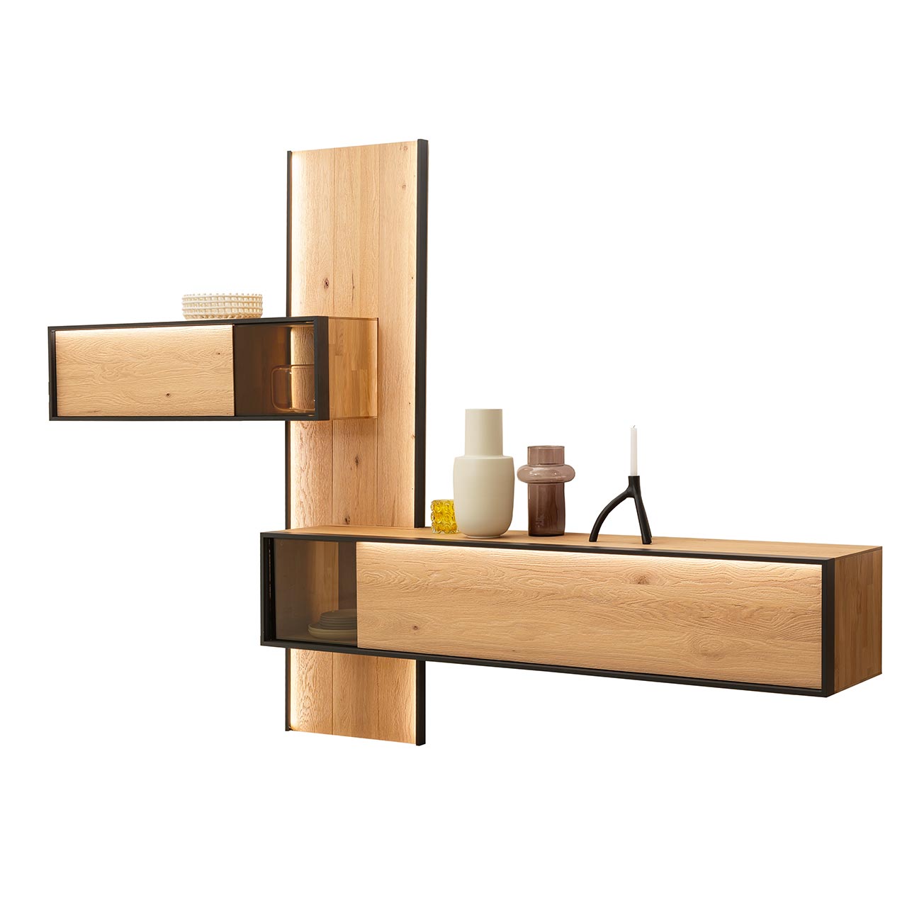Hartmann YOLA Schöner Wohnen - Wohnkombination 8590 Nr. V20SV Minimalistische Wohnwand aus massiver, sandgestrahlter Kerneiche Natur mit anthrazitfarbenem Metallrahmen, bestehend aus langem, beleuchtetem Wandpaneel, oben seitlich angebrachtem Hängeregal mit Glasausschnitt und Lowboard mit Glasdetail unten.