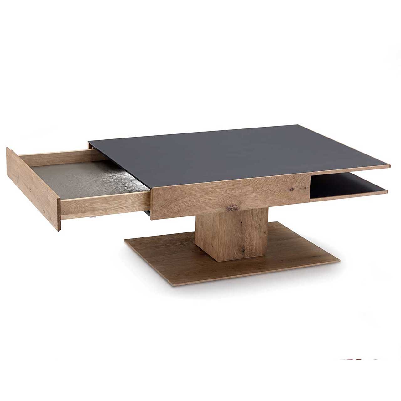 Hartmann CAYA - Couchtisch 7170-0446 - Schubkasten offen Moderner, rechteckiger Couchtisch aus massiver Kerneiche Umato. Dicke Tischplatte in Mattglas Anthrazit mit integriertem, geöffnetem Schubkasten und seitlichem Ablagefach, auf massiver, rechteckiger Holzsäule und Bodenplatte stehend.