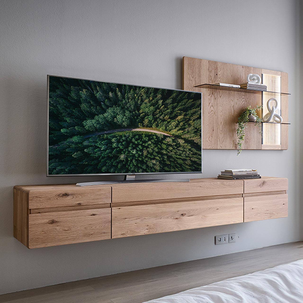 Hartmann VIDA - Wohnkombination 8630 Nr. V24 - zweiteilig - Kerneiche Natur Moderne zweiteilige Wohnwand aus massiver Kerneiche Natur bestehend aus einem langen Hängelowboard mit Türen und Klappe sowie einem Wandpaneel mit beleuchteten Glasböden sowie geschroppter Rückwand.