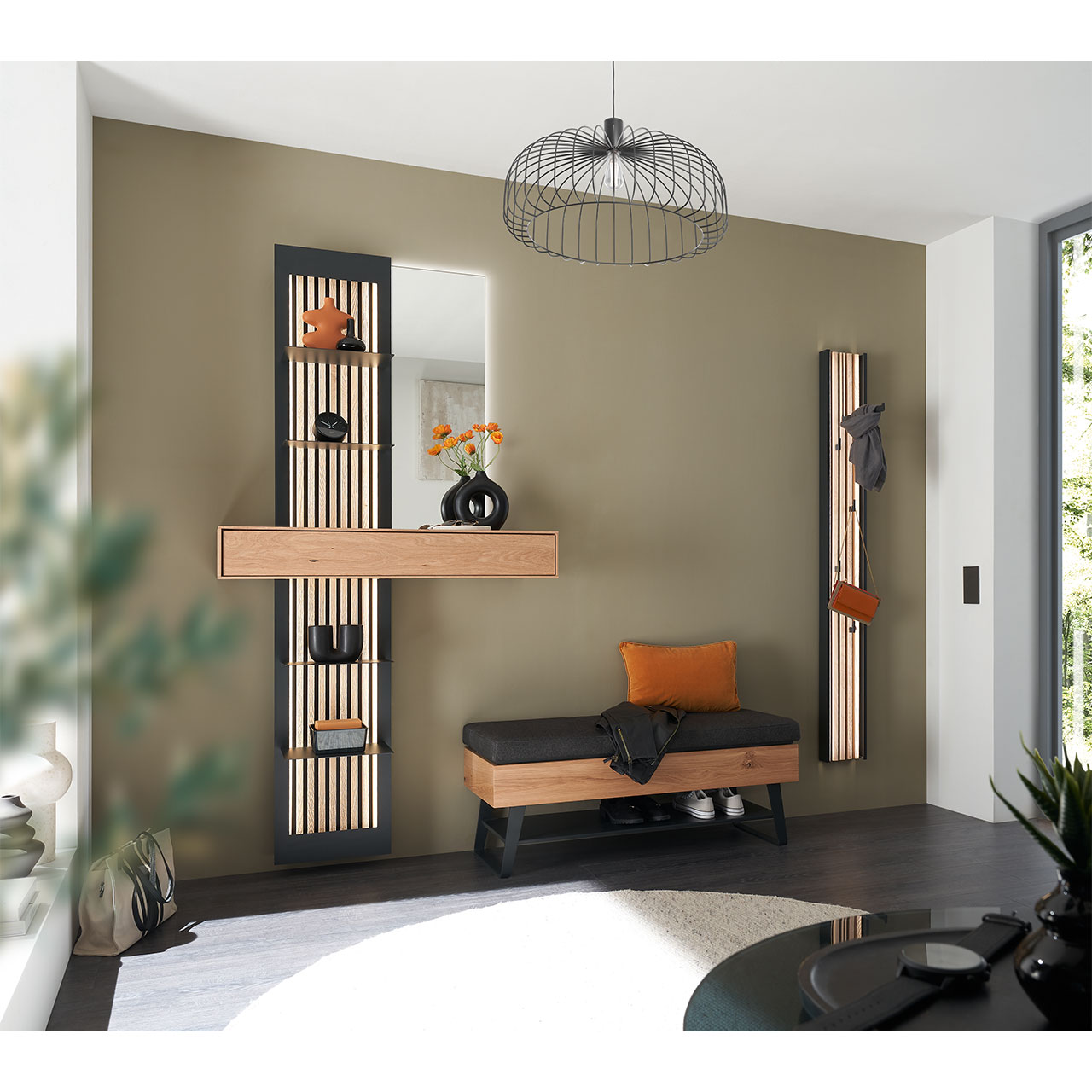 Milieubild Hartmann SALVO 8550G -  Garderobe Nr. V102L - Kerneiche Natur, Metall anthrazit, Lamellen Flur mit modernen Garderobenmöbeln aus massiver Kerneiche Natur: Ein Regalelement mit Schubkasten, Ablageböden und Holzlamellen, eine Wandgarderobe mit Lamellen-Rückwand und eine Sitzbank auf Metallkufen mit Stauraumfach.