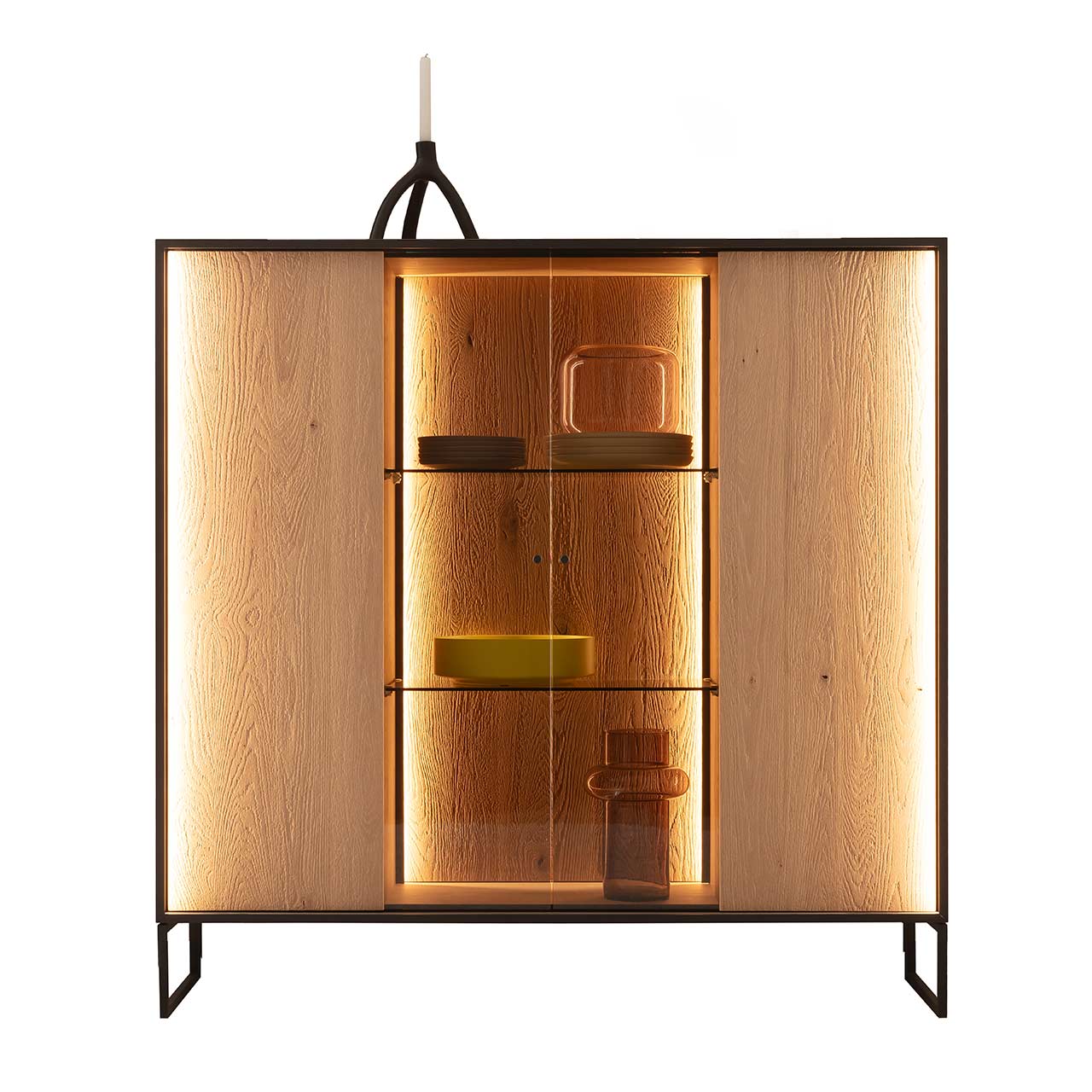 Hartmann YOLA Schöner Wohnen - Highboard mit niedrigen Kufen 8590-6133 Modernes Highboard aus massiver, sandgestrahlter Kerneiche Natur mit beleuchtetem, rundum Metallrahmen und zwei filigranen Metallfüßen in Anthrazit. Mit zwei Holztüren links und rechts, mittig verglaster Vitrinenbereich mit beleuchteten Glaseinlegeböden.