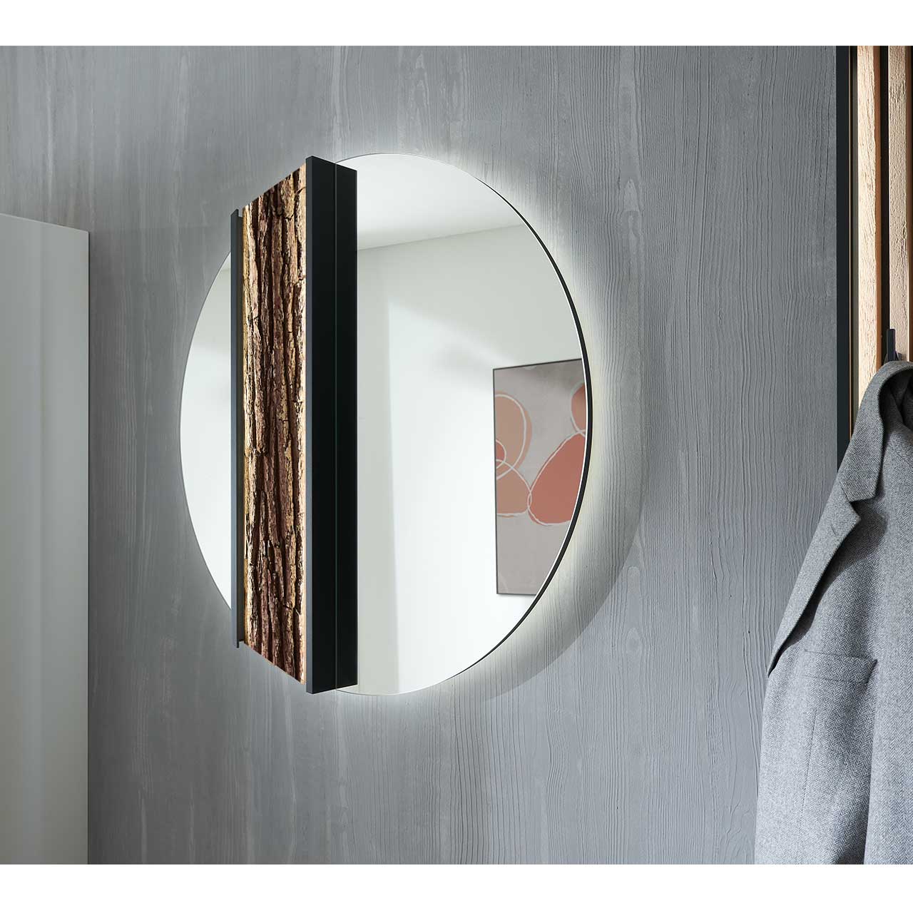 Hartmann SALVO Garderoben - Wandspiegel 8550G-5093 li - mit Baumrinde Seitenansicht eines runden Wandspiegels, links mit Rinden-Akzent eingefasst in einen anthrazitfarbenen Metallrahmen.