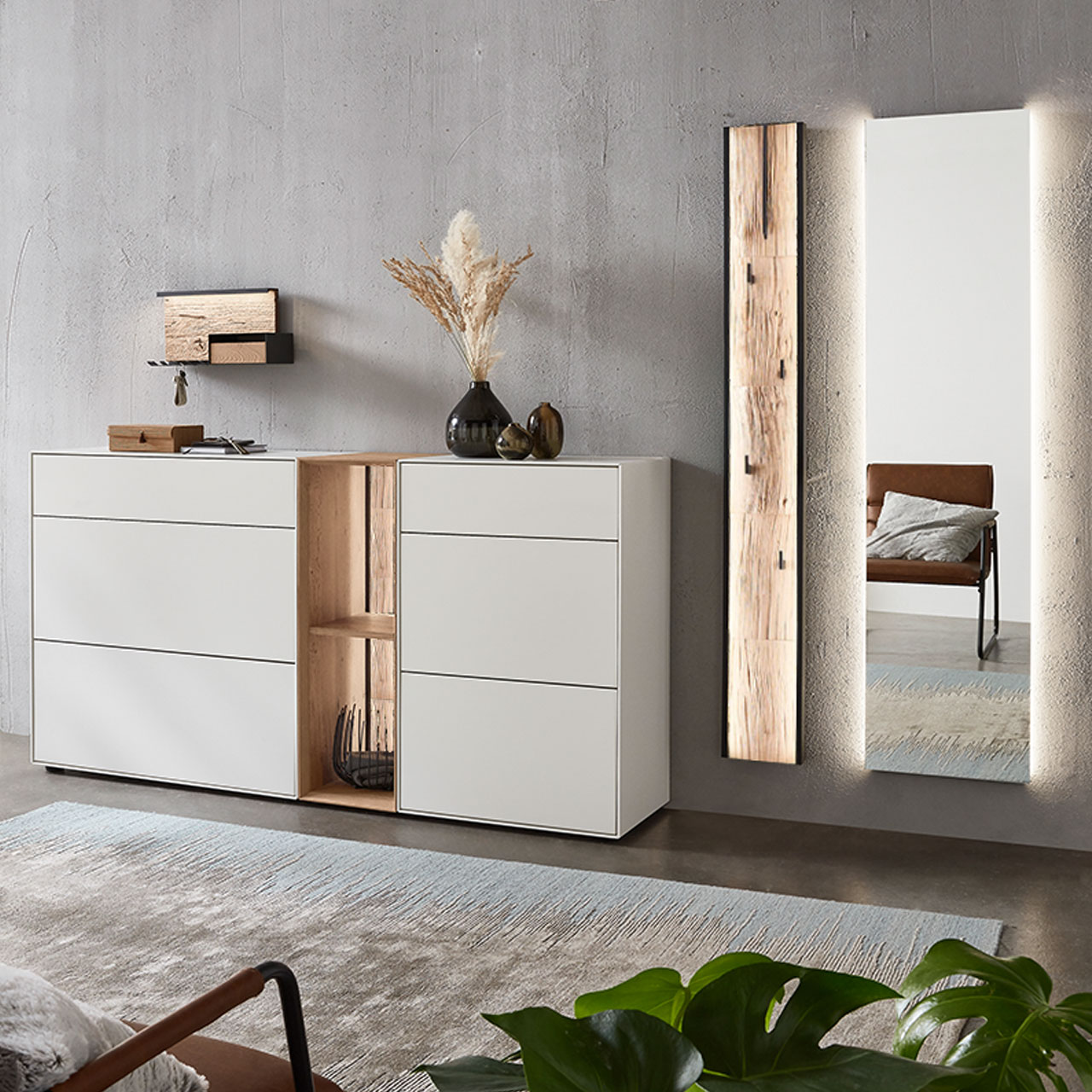 Moderne fünfteilige Garderobe aus massiver Kernbirke und Kerneiche Natur: Regalelement mit Spaltholz-Rückwand zwischen zwei weiß lackierten Stauraumschränken, dazu ein Garderobenpaneel mit Spaltholz-Akzent und ein rechteckiger Spiegel.