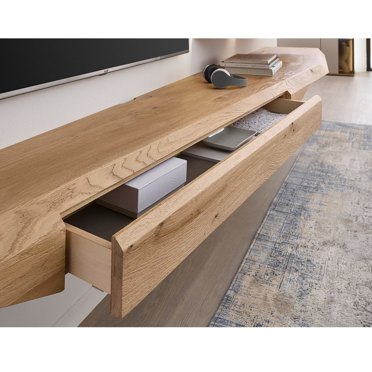 Modernes, langes Hängelowboard aus massivem Riffholz im asymmetrischem Design mit geöffnetem Schubkasten.