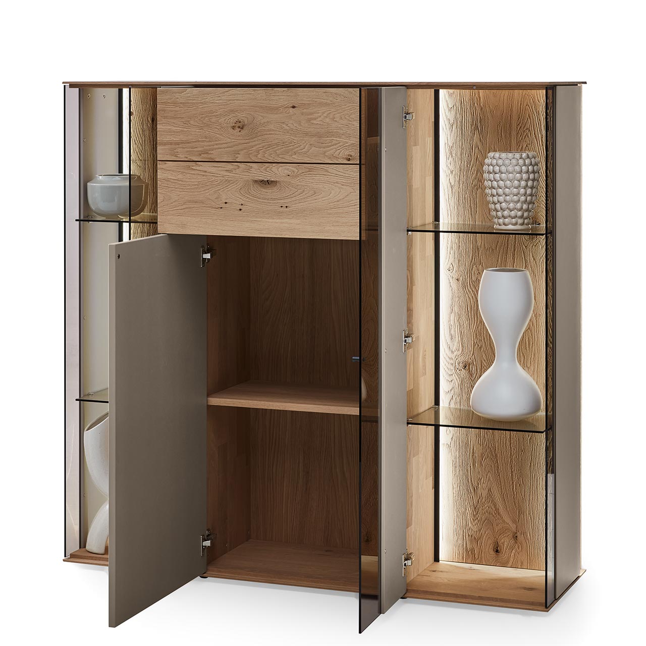 Hartmann Möbel SVEA - Highboard 8660-7141 offen - Kerneiche Natur, Lack Sand Modernes Highboard aus massiver Kerneiche Natur mit Lackfronten in Sand und Riffholz mit Glas-Lacktüren und Schubkasten. Die Lacktür mittig und die Glastür rechts sind geöffnet. Innenliegend sichtbar Holz- und Glaseinlegeböden.