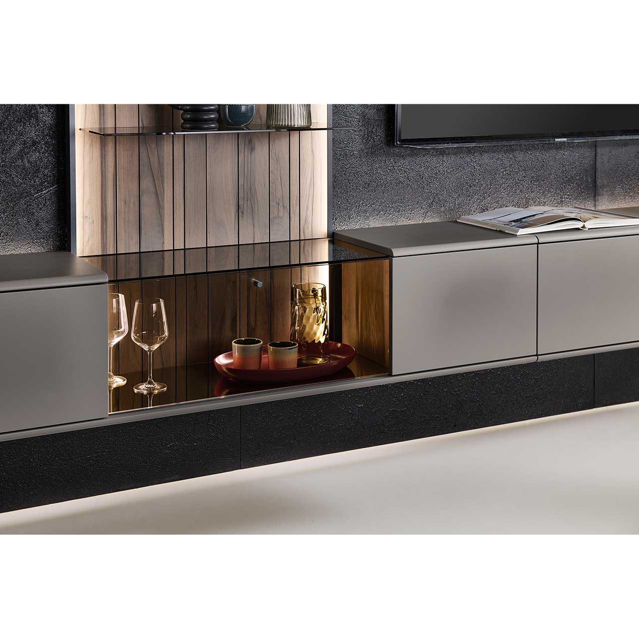 Detailansicht der Wohnwand mit Fokus auf das Lowboard 2173 mit geschlossener Klappe und angeschalteter Beleuchtung des Paneels in der Mitte.