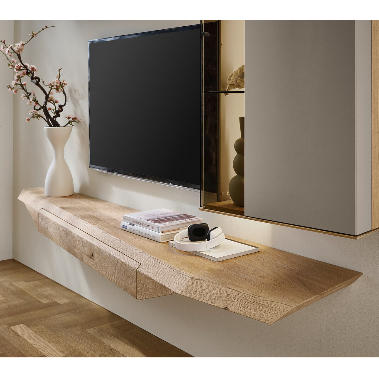 Modernes Hängelowboard aus massivem Riffholz im asymmetrischem Design mit praktischem Schubkasten.
