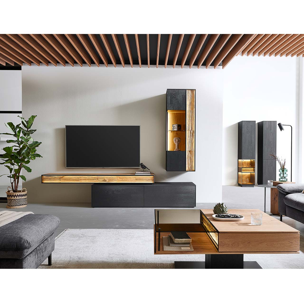 Moderne Wohnwand mit Materialmix aus Lack anthrazit mit Spaltholz-Akzenten und Parsolglas-Vitrinenausschnitten