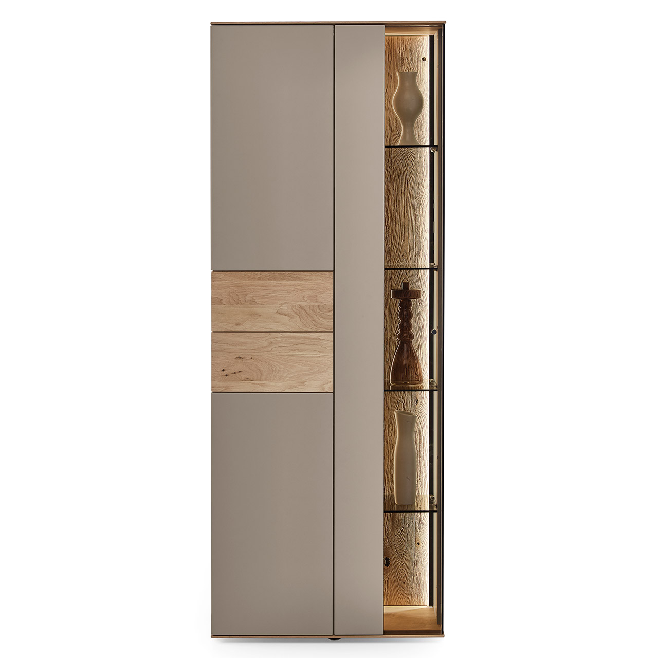 Hartmann Möbel SVEA - Standvitrine 8660-0071 - Kerneiche Natur, Lack Sand Moderne Vitrine aus massiver Kerneiche Natur mit Lackfronten in Sand. Mit einer Glas-Lacktür mit edler, beleuchteter Riffholzrückwand und einer Lacktür mit eingearbeitetem Riffholz - in Frontansicht.