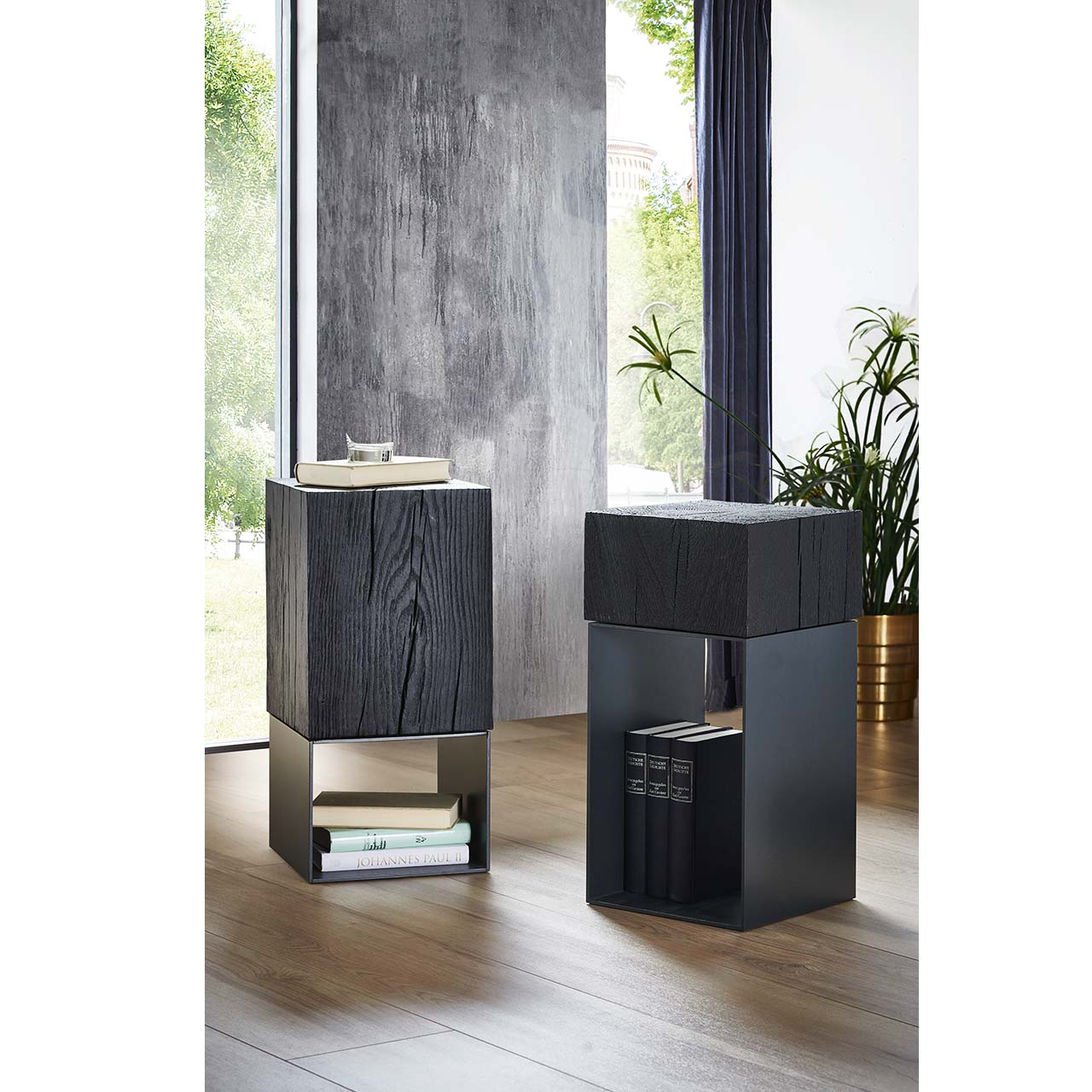 Zwei quadratische Beistelltische mit Aufsatzblock aus Kernesche in Anthrazit und Untergestell aus dunklem Metall – im Wohnzimmer stehend.