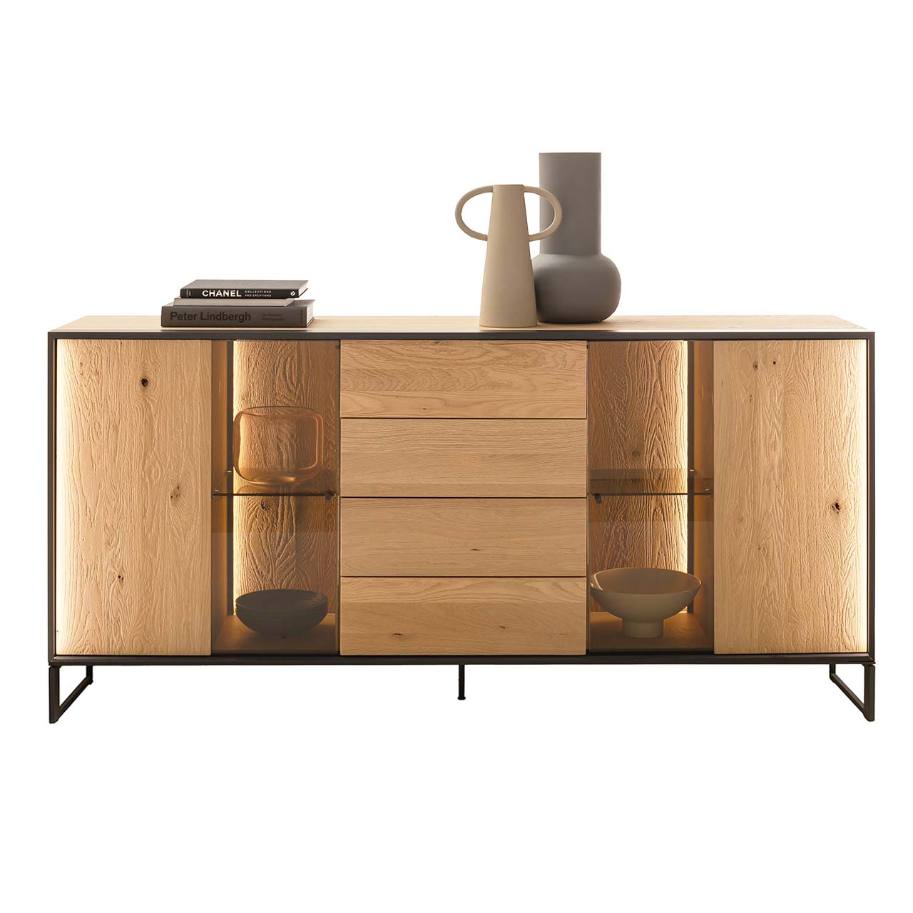 Hartmann YOLA Schöner Wohnen - Sideboard mit niedrigen Kufen 8590-4193 Modernes Sideboard aus massiver, sandgestrahlter Kerneiche Natur mit beleuchtetem Metallrahmen und zwei filigranen Metallfüßen in Anthrazit. In der Mitte ein Schubkasten und eine Tür, links und rechts Türen mit beleuchteten Glasausschnitten.