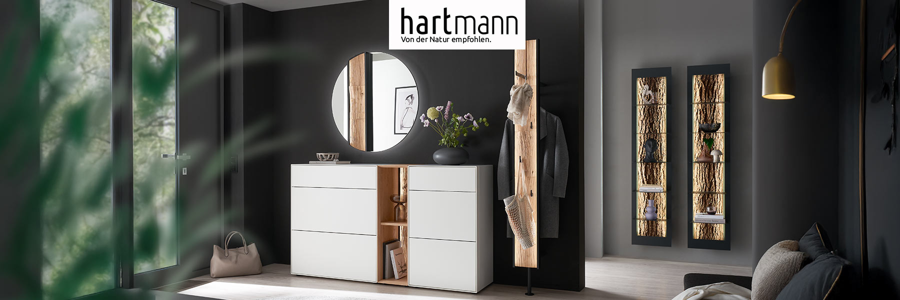 Hartmann Garderoben Möbel - Möbelserie SALVO - Kerneiche Natur und Birke Lack weiß Hartmann SALVO - Flurmöbel aus massiver Kerneiche Natur und Birke weiß lackiert kombiniert mit Akzenten aus echter Baumrinde, Holzlamellen oder Spaltholz. Ambientebild zeigt zwei weiße Stauraumschränke, runden Wandspiegel und eine Wandgarderoben.