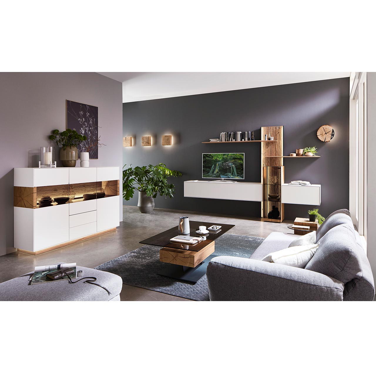 Modernes Wohnzimmer mit Wohnwand aus weißem Lack in Kombination mit Massivholzpaneel und Glasvitrine, dazu passendes Sideboard