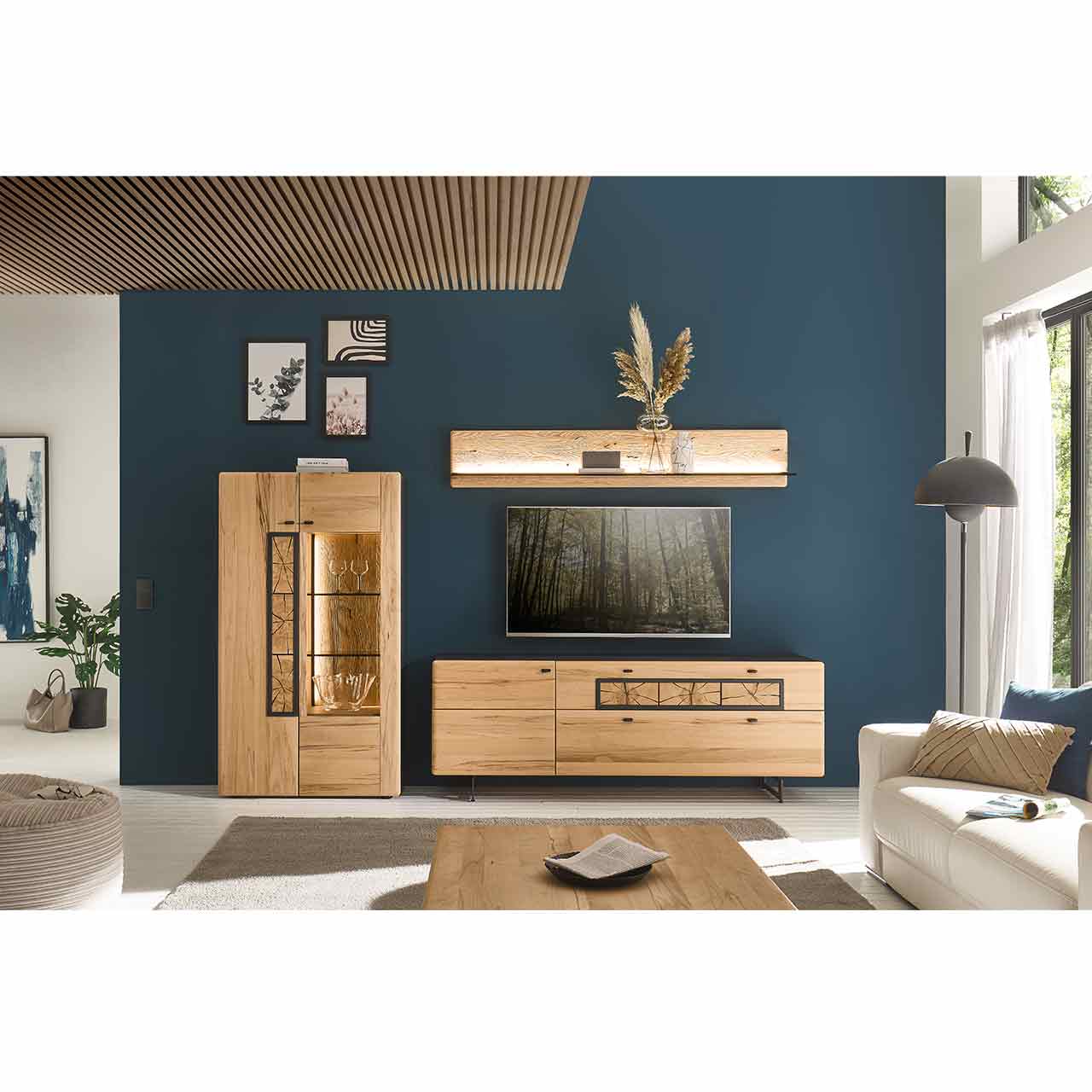 Modernes Wohnzimmer mit dreiteiliger Wohnwand aus Kernbuche und dekorativen Hirnholzscheiben: Highboard, Lowboard und Wandpaneel vor dunkelblauer Wand, dazu passender Couchtisch.
