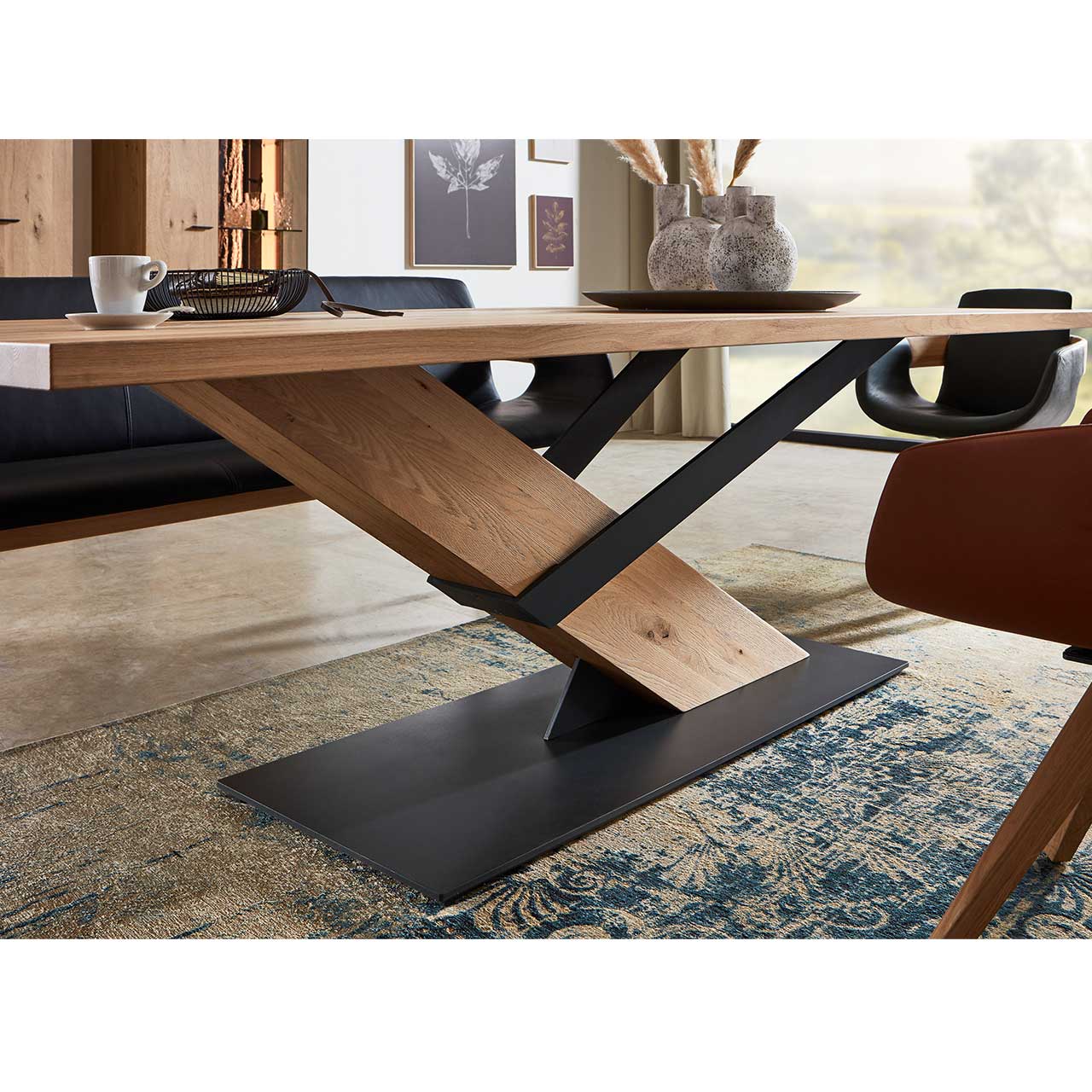 Milieubild EMilieubild Esszimmer - Hartmann NATURZEIT 7100E/8400E - 1508 Esstisch - Detail Gestellsszimmer - Hartmann NATURZEIT 7100E/8400E - 1508 Esstisch Detailannahme des Gestells eines Holztisches - massiver Holzbalken eingefasst mit Metallstreben in anthrazit auf massiver anthrazitfarbener Bodenplatte.