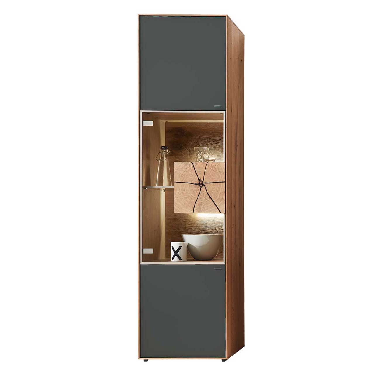 Moderne Standvitrine aus massiver Kerneiche Umato mit Mattglas anthrazit Front, mittig mit beleuchtetem Glasausschnitt, Glasboden und Hirnholzblock aus hellem Holz. 