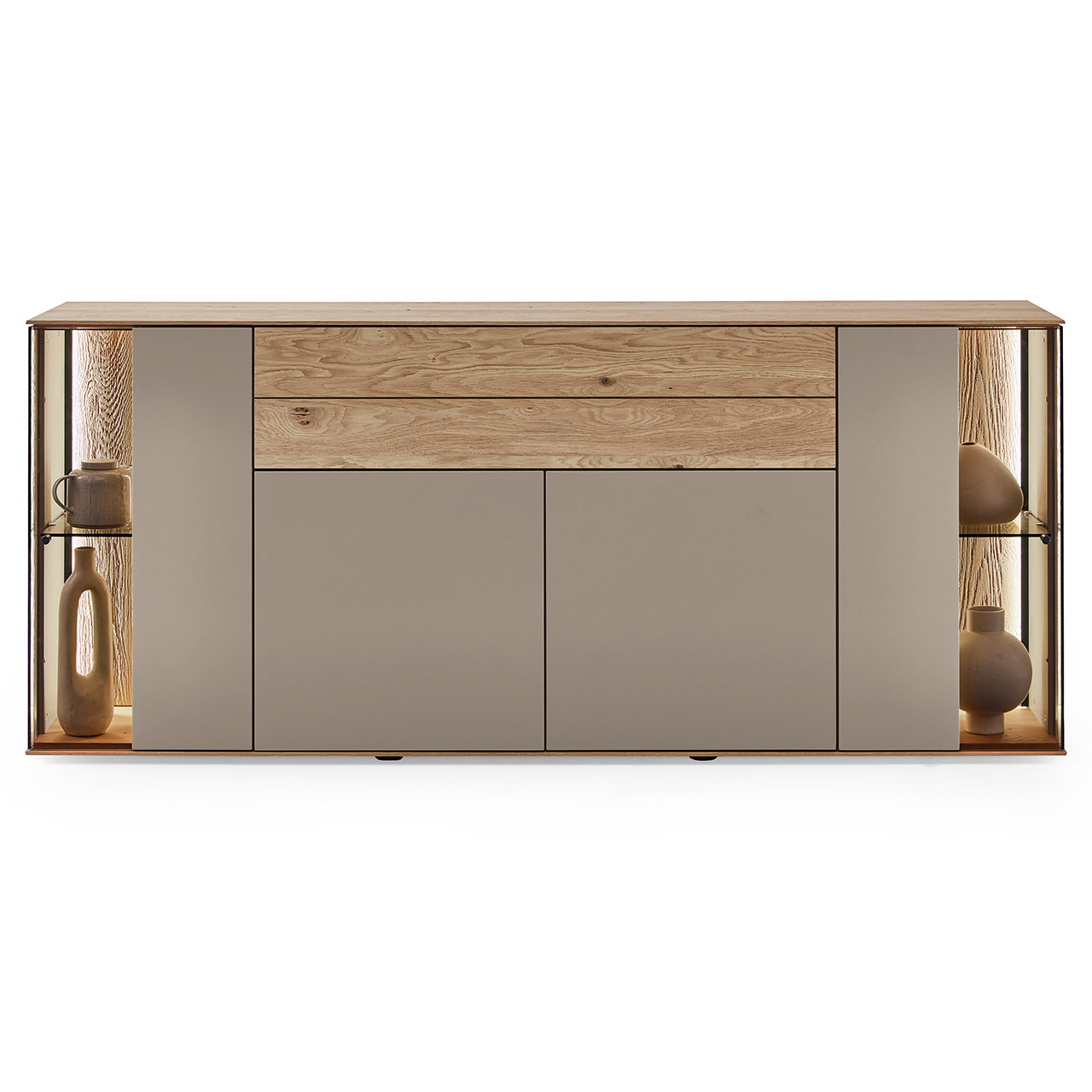 Hartmann Möbel SVEA - Sideboard 8660-4191 - Kerneiche Natur, Lack Sand Moderne Kommode aus Massivholz mit Lackfronten in Sand und edlem Riffholz. Mit zwei Lacktüren unten, einem langen Schubkasten mit Riffholzfront oben und je einer Glas-Lacktür rechts und links mit beleuchteter Riffholzrückwand - in Frontansicht.