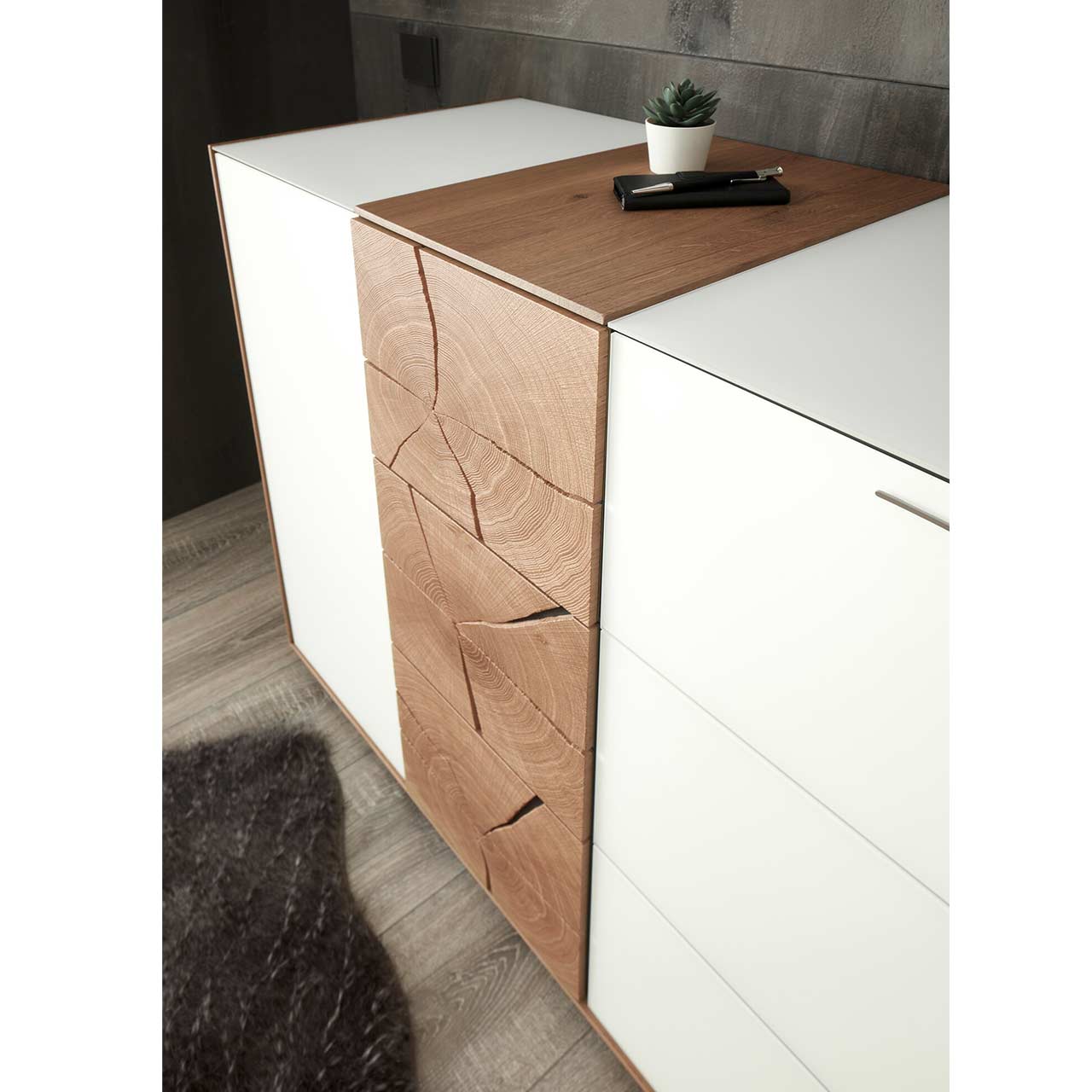 Detailaufnahme der dekorativen, mittig verlaufenden Hirnholzscheiben einer Kommode aus massivem Holz mit Fronten in Mattglas.