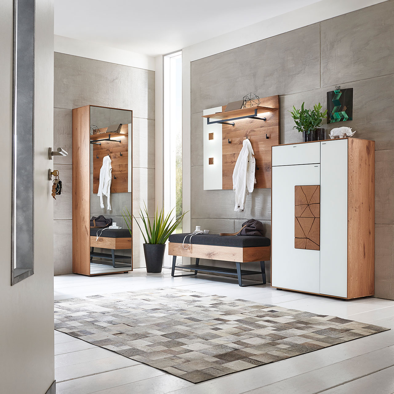 Moderne Garderobe aus Massivholz und Metall: Wandpaneel mit Stange und Haken, Stauraumschrank mit weißen Mattglasfronten und Hirnholz, Hochschrank mit Spiegeltür und einer gepolsterten Sitzbank in schwarzem Stoff mit Stauraumfach und Metallablage.