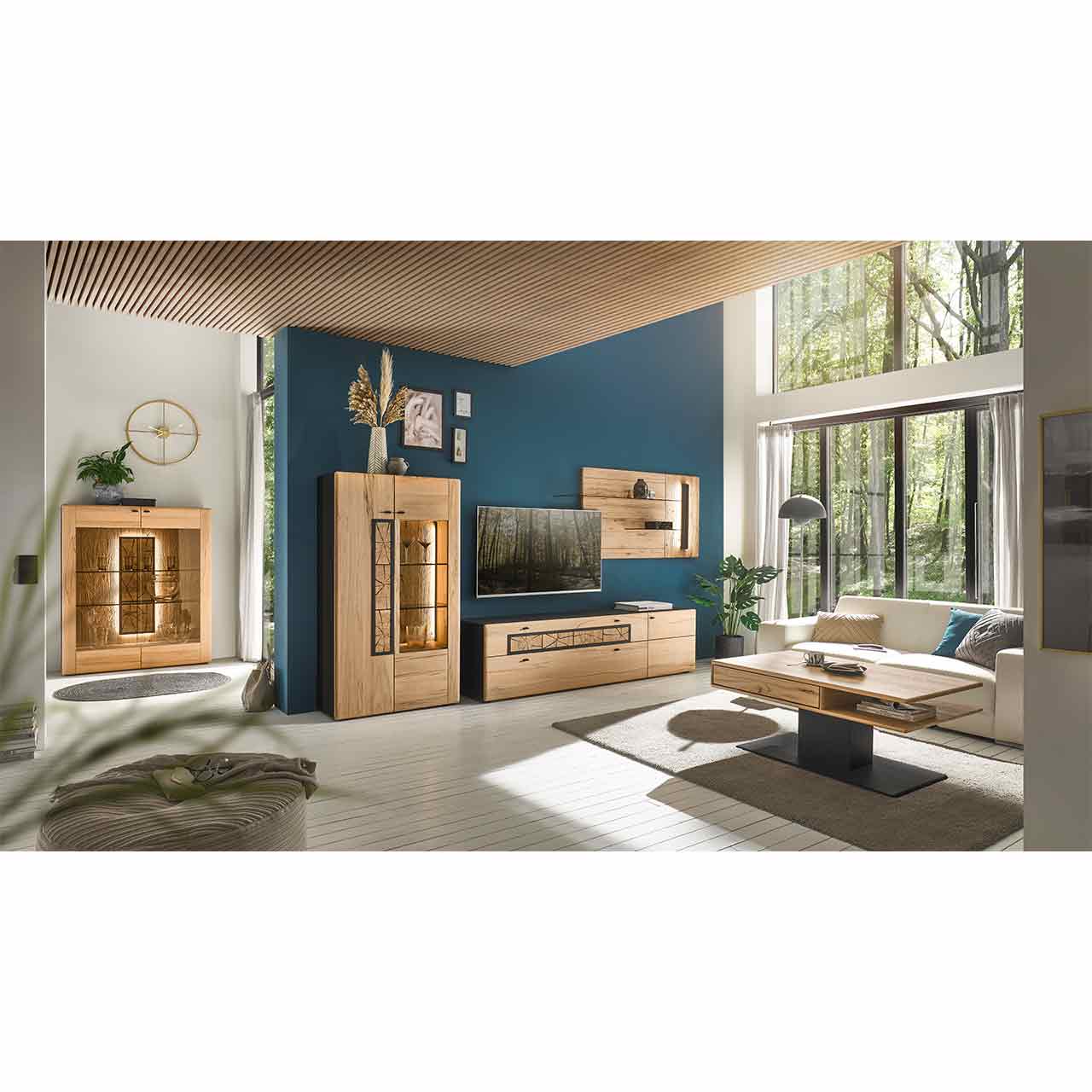 Modern eingerichtetes Wohnzimmer mit dreiteiliger Wohnwand aus Kernbuche: Highboard, Lowboard und Wandpaneel. Im Hintergrund links weiteres Highboard mit Glasfront, im Vordergrund rechts passender Couchtisch.