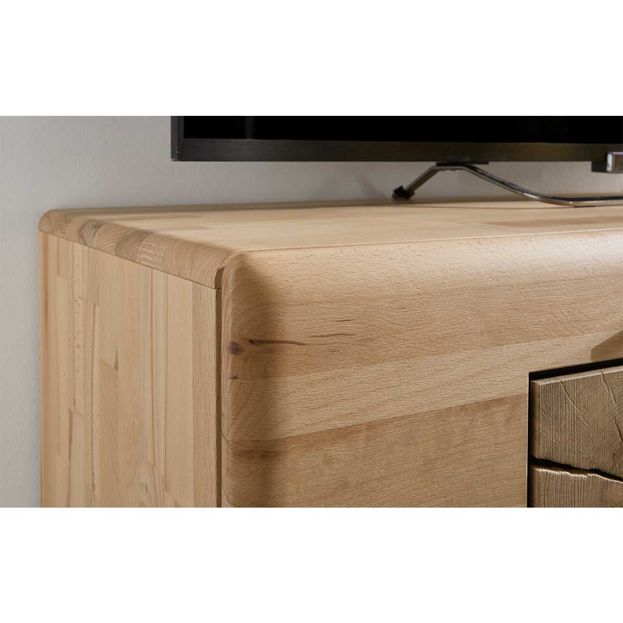 Detailaufnahme der linken vorderen Holzkante eines KVIK Lowboards. Die Holzkante, aus massiver Kernbuche, ist abgerundet.