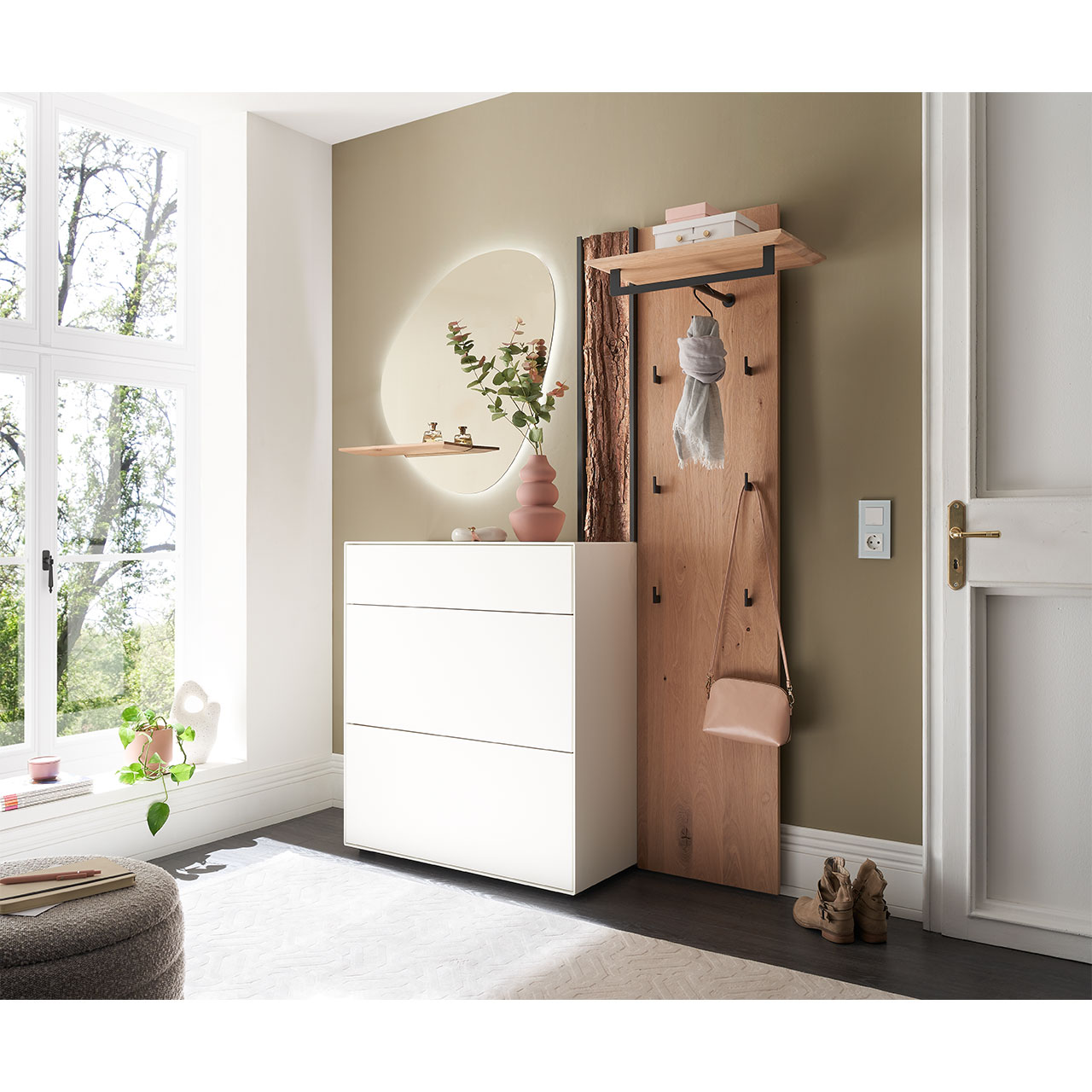 Milieubild Hartmann SALVO 8550G -  Garderobe Nr. V106R - Kernbirke weiß Lack, Kerneiche Natur, Baumrinde Flur mit modernen Garderobenmöbeln aus Kernbirke und Kerneiche Natur: Wandpaneel aus Holz mit Kleiderstange, Haken und Rinden-Akzent. Ein Stauraumschrank mit Schubkasten und Klappen in Lack weiß, ein ovaler Spiegel mit Ablage.