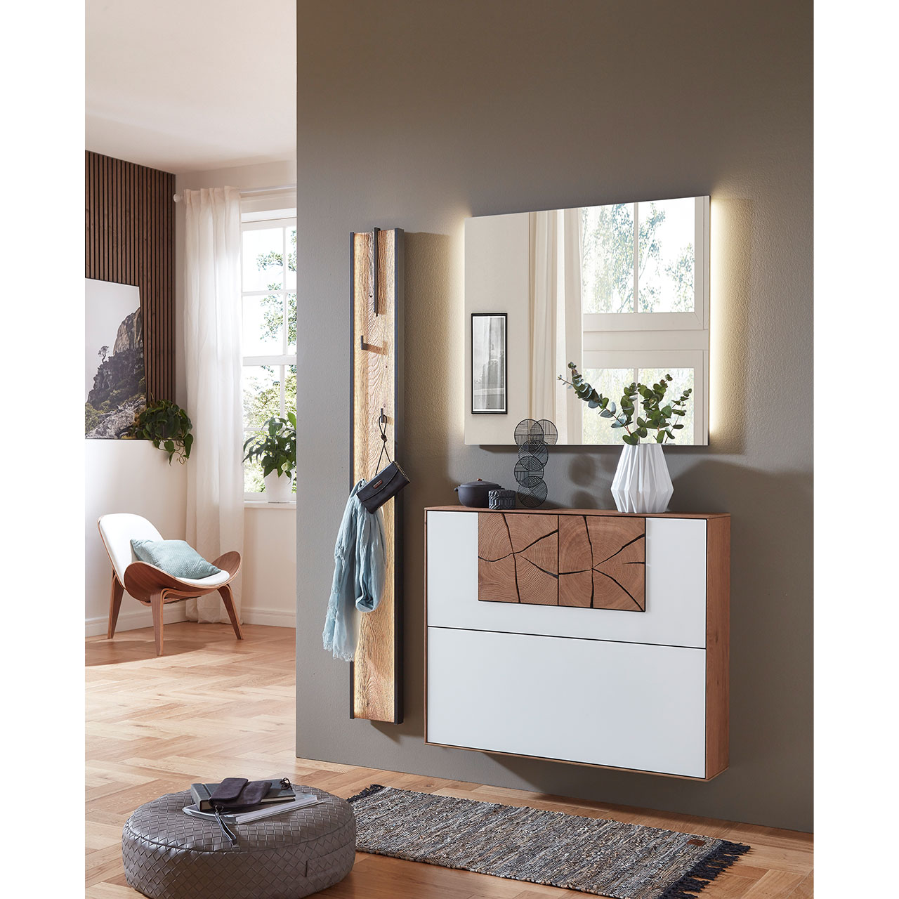 Milieubild - Hartmann CAYA Garderoben - Kombination 7140 Nr. V130 Dreiteilige Garderobe aus massiver Kerneiche mit beleuchtetem Spiegel, einem Schuhkipper mit weißer Mattglasfront und Hirnholzscheiben und einem Garderobenpaneel mit Stange und Haken aus Riffholz und Metall Anthrazit - vor dunkelgrauer Wand.