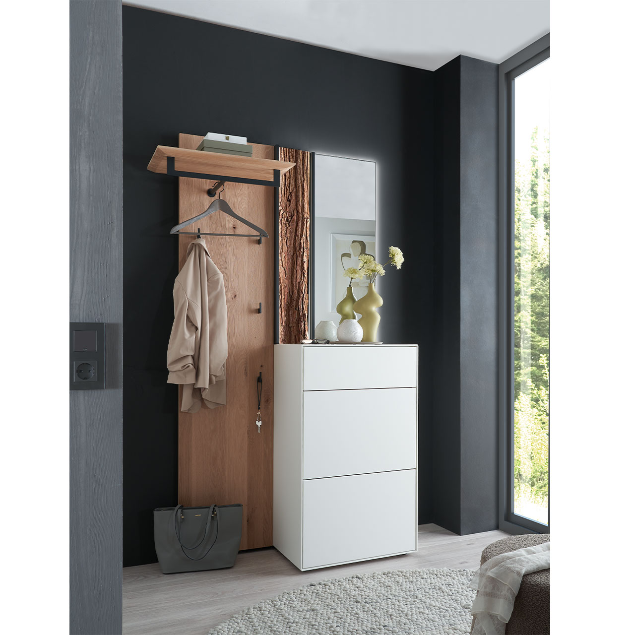 Milieubild Hartmann SALVO 8550G -  Garderobe Nr. V106R - Kernbirke weiß Lack, Kerneiche Natur, Baumrinde Flur mit modernen Garderobenmöbeln aus Kernbirke und Kerneiche Natur: Wandpaneel aus Holz mit Kleiderstange, Haken und Rinden-Akzent, ein Stauraumschrank mit Schubkasten und Klappen in Lack weiß, ein rechteckiger Spiegel.