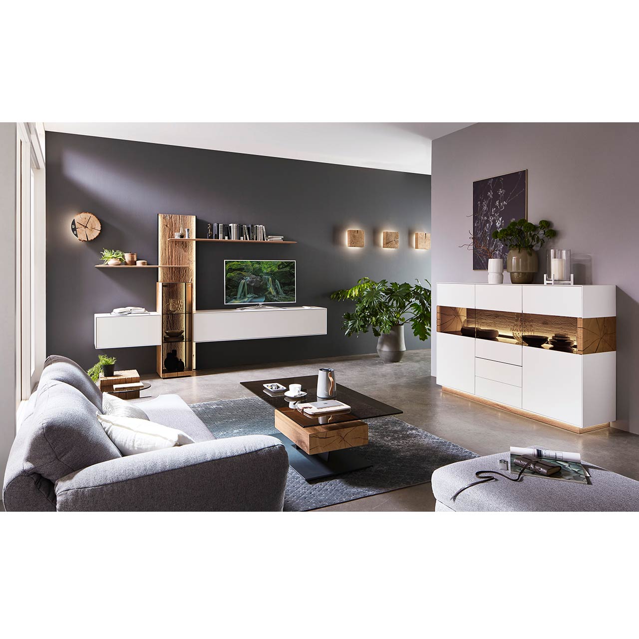 Modernes Wohnzimmer mit Wohnwand aus weißem Lack in Kombination mit Massivholzpaneel und Glasvitrine, dazu passendes Sideboard