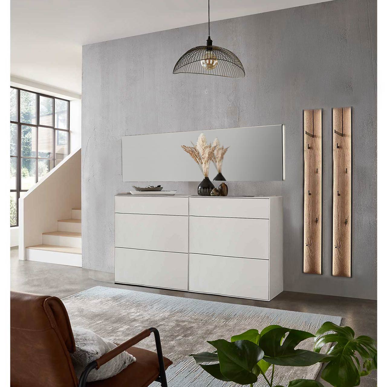 Flur mit modernen Garderobenmöbeln aus massiver Kernbirke in Lack weiß: Zwei Stauraumschränke mit Schubkästen, zwei Garderobenpaneele mit je einer Kleiderstange, vier Mantelhaken und Spaltholz-Akzent und ein langer Wandspiegel.