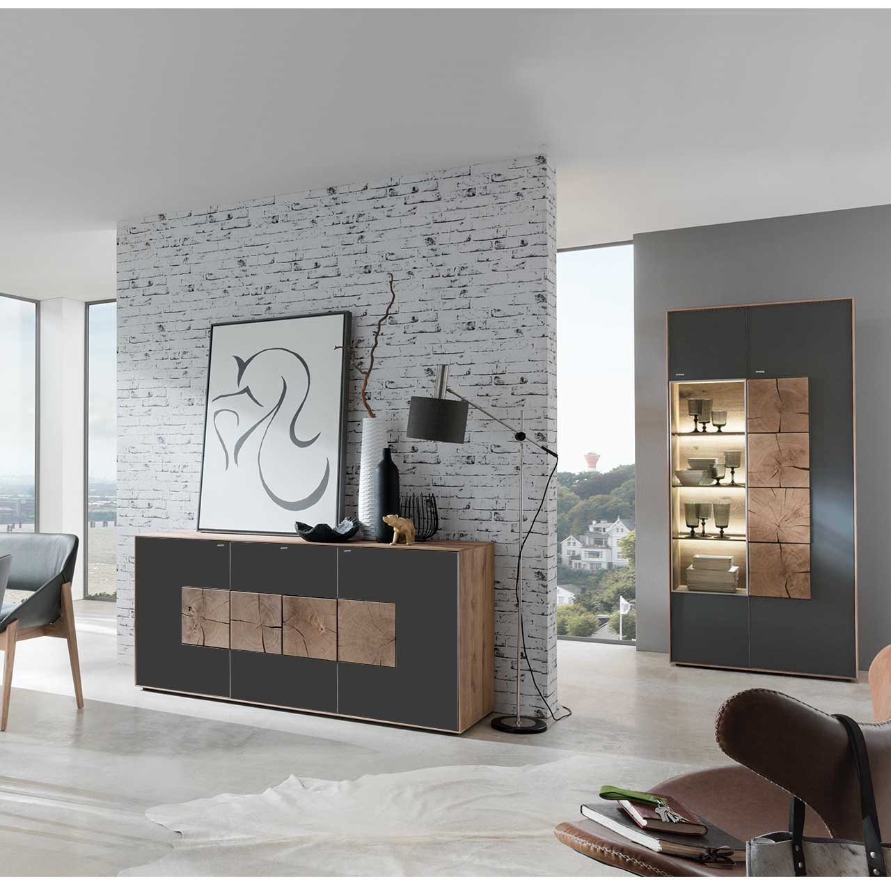 Flur mit modernem Sideboard aus massivem Holz mit Mattglas anthrazit Front und vier Hirnholzscheiben. Im Hintergrund an einer Wand stehend eine Strandvitrine in Mattglas anthrazit und beleuchtetem Glasausschnitt mit drei Glasböden.