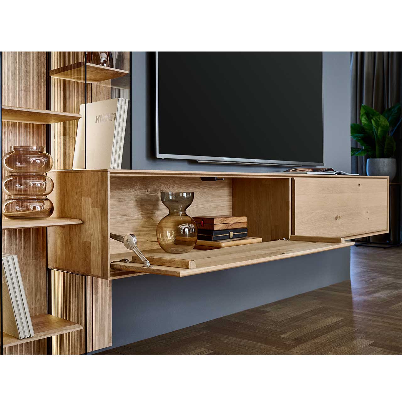 Modernes Hängelowboard aus massiver Kerneiche Natur mit zwei Holzklappen, die linke ist geöffnet.