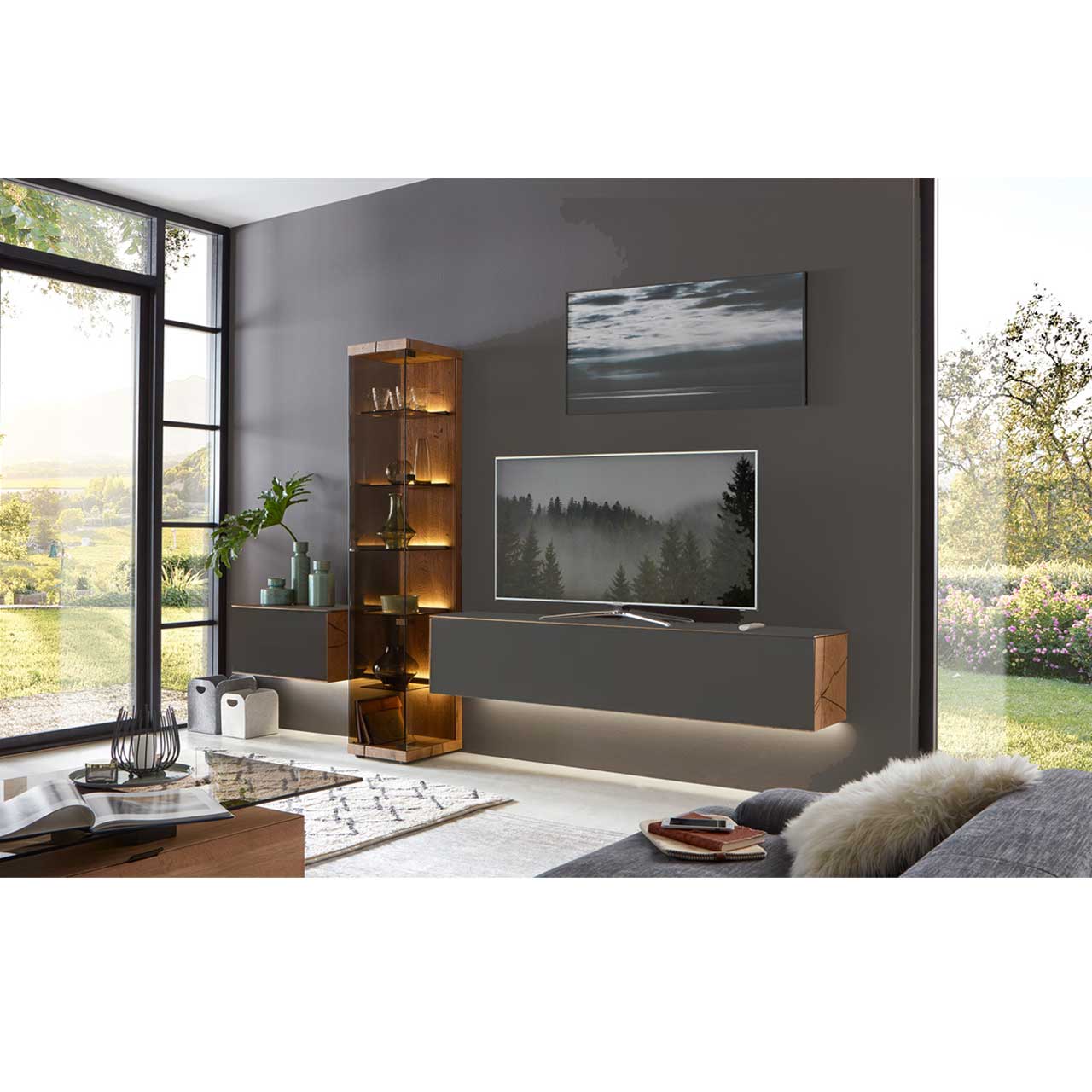 Dreiteilige Massivholz Wohnwand aus Kerneiche mit Metall anthrazit Fronten, bestehend aus zwei Hängelowboards in anthrazit und einer mittig stehenden edlen Glasvitrine.