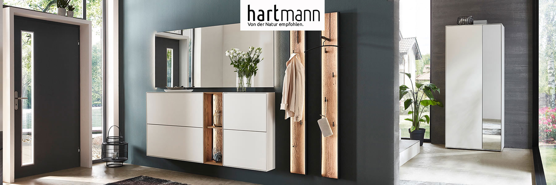 Hartmann VELKO - Flurmöbel aus massiver Birke weiß lackiert kombiniert mit Kerneiche Umato und Metall anthrazit. Ambientebild zeigt zwei weiße Schuhkipper dazwischen beleuchtetes Regal mit edler Holzwand, großer Wandspiegel und zwei Wandgarderoben.