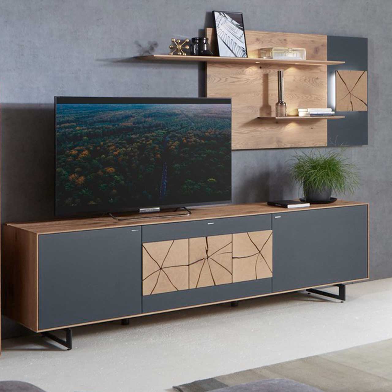 Moderne Massivholz Wohnwand mit Mattglas Anthrazit Fronten bestehend aus Lowboard auf zwei Metallkufen in Anthrazit und zwei dekorativen Hirnholzscheiben und einem Wandpaneel mit zwei Regalböden und beleuchteter, rechteckiger Hirnholzscheibe