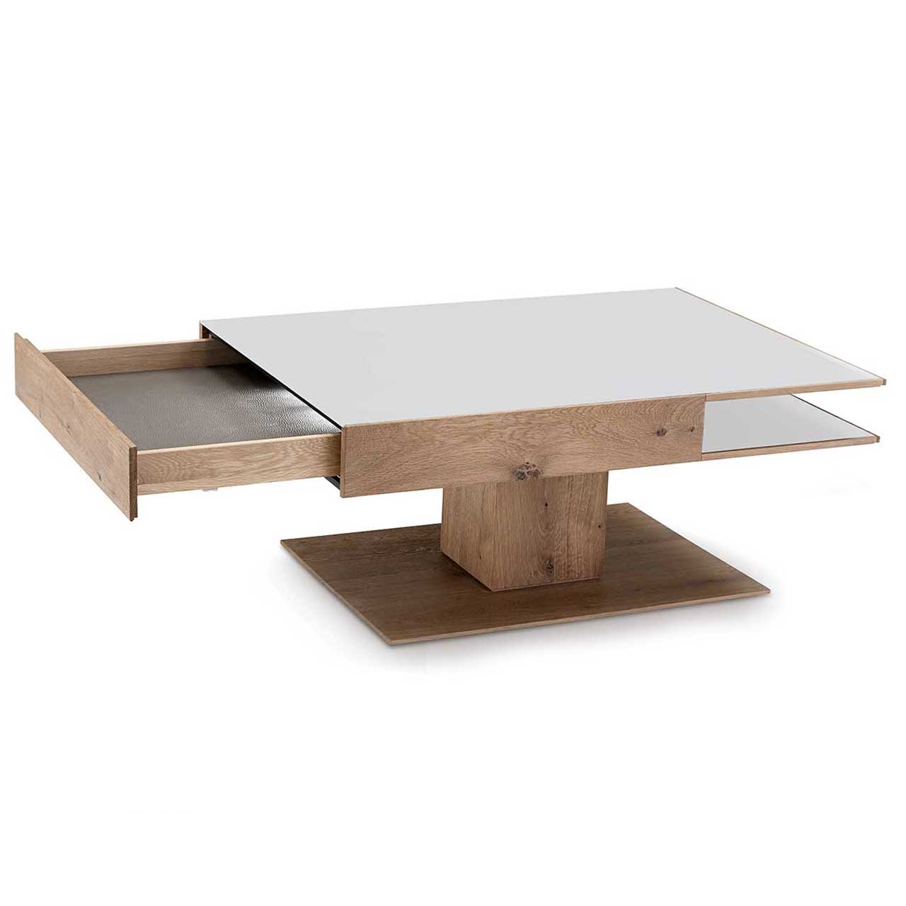 Moderner, rechteckiger Couchtisch aus massiver Kerneiche Umato. Dicke Tischplatte in Mattglas weiß mit integriertem, geöffnetem Schubkasten und seitlichem Ablagefach, auf massiver, rechteckiger Holzsäule und Bodenplatte stehend.