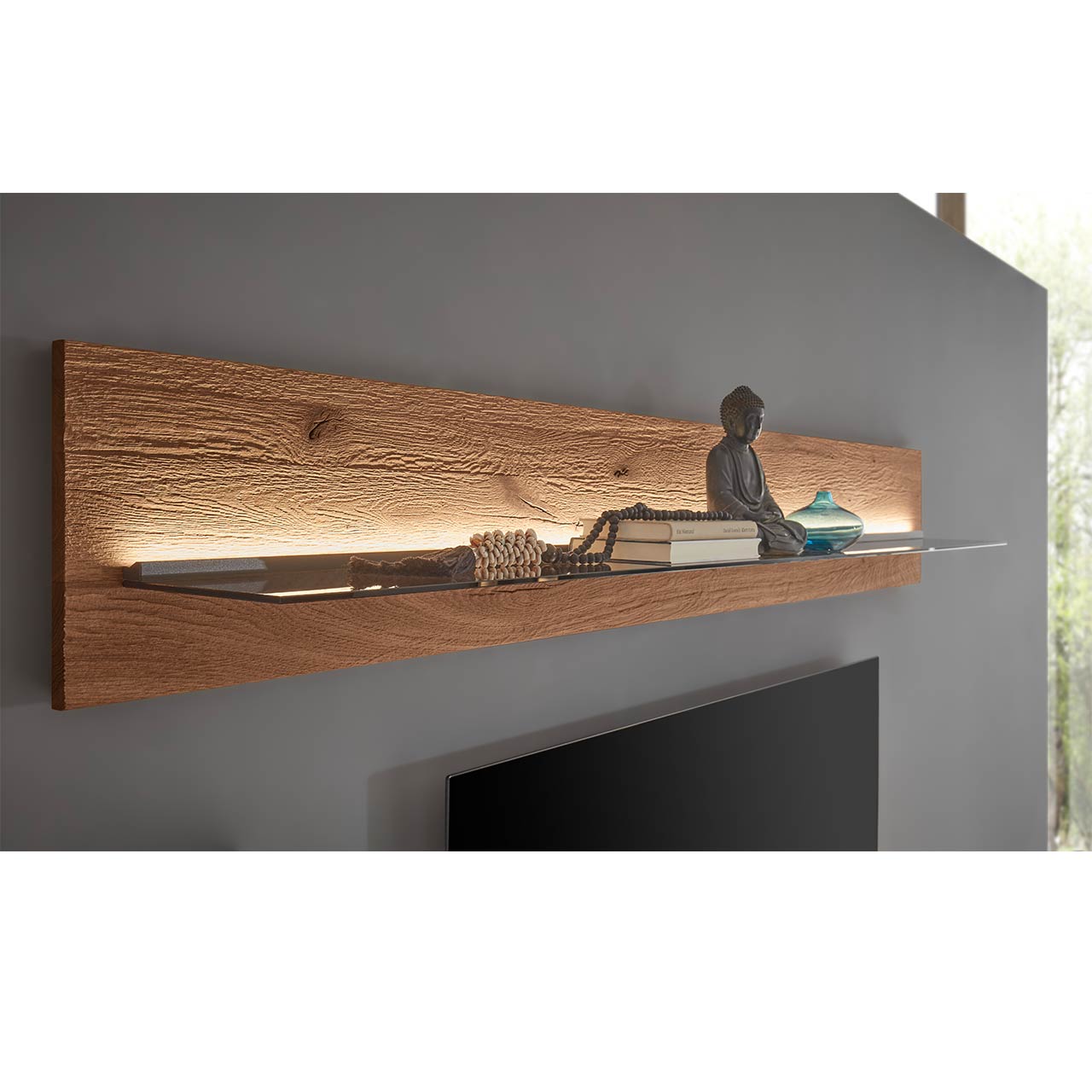 Seitliche Ansicht eines länglichen Wandpaneels aus dunkler Kerneiche mit beleuchtetem Glasboden an dunkelgrauer Wand.