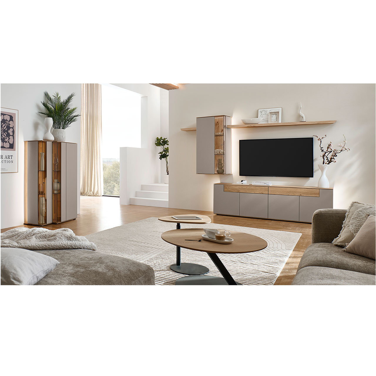 Wohnzimmer mit moderner Massivholzwohnwand bestehend aus einem Lowboard mit Schubkästen, einer Hängevitrine sowie zwei Wandboarden mit Holzboden - im asymmetrischen Design. Links passendes Highboard, davor Holz-Couchtisch.